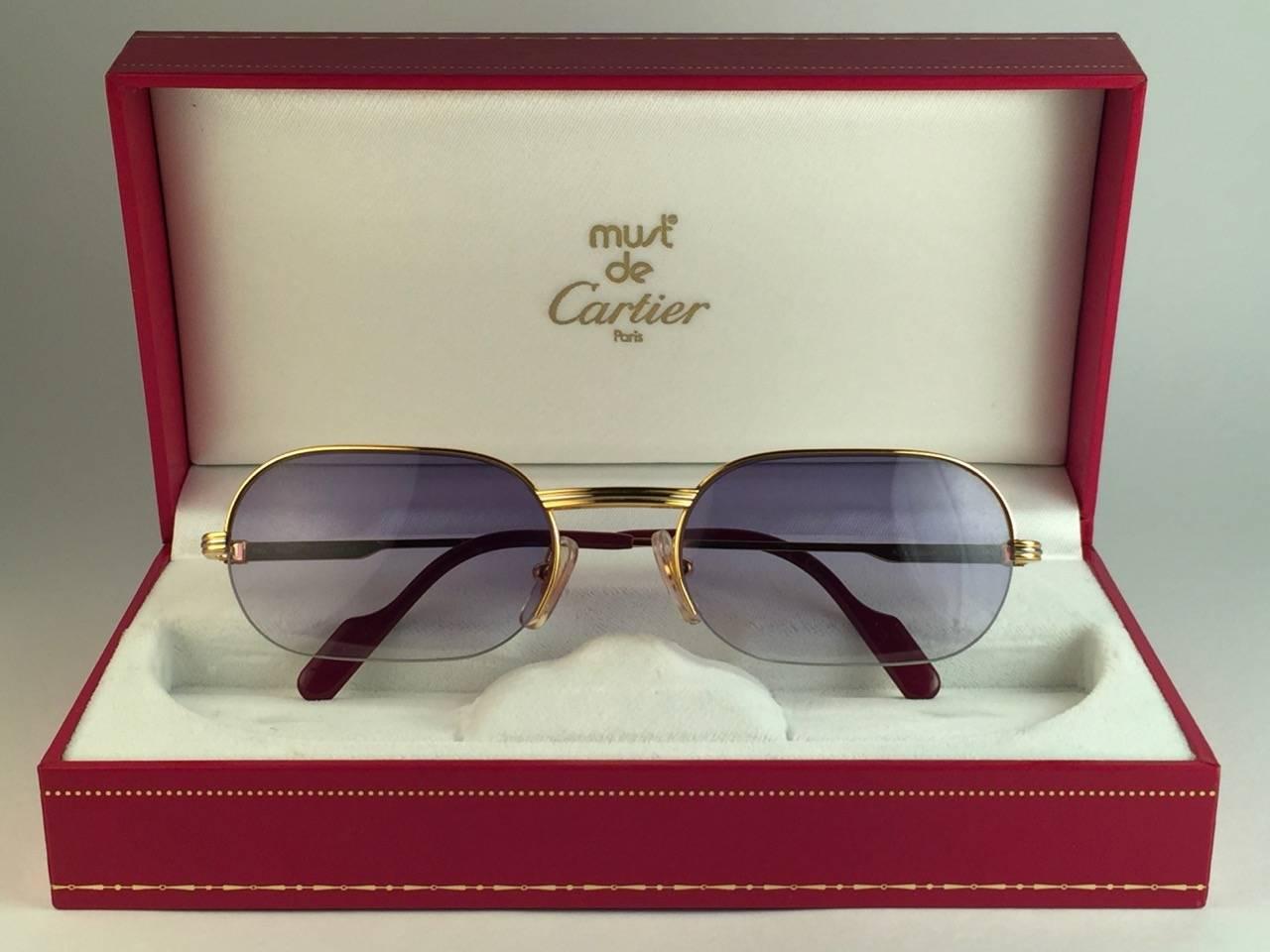 New 1983 Cartier Ascot Vendome Gold 53mm Half Frame with blue gradient (uv protection) lenses. 
Frame is with the front and sides in white and yellow gold heavy 18k plated accents. All hallmarks. Burgundy with Cartier gold signs on the earpaddles.