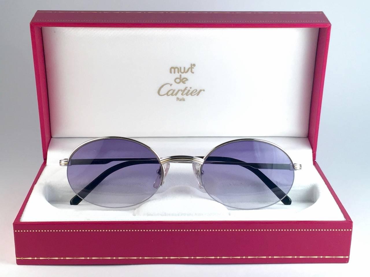 New Cartier oval Manhattan sunglasses with blue gradient lenses(uv protection).  All hallmarks. Silver Cartier signs on the ear paddles. 
Both arms sport the knot from Cartier on the temple. These are like a pair of jewels on your nose. 
Beautiful