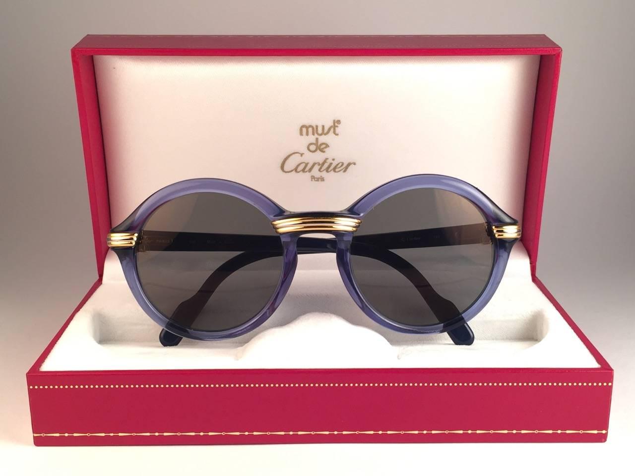 New 1991 Original Cartier Cabriolet Art Deco Translucent Blue sunglasses with Original Cartier G15 Slight Gold Mirror ( uv protection ) lenses.
Frame has the famous real gold and white gold accents in the middle and on the sides. 
All hallmarks.