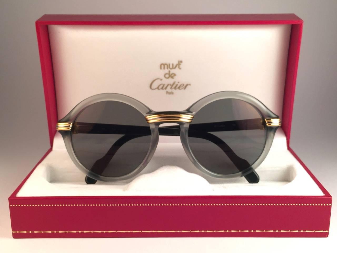 New 1991 Original Cartier Cabriolet Art Deco Translucent Jade sunglasses with grey ( uv protection ) lenses.
Frame has the famous real gold and white gold accents in the middle and on the sides. 
All hallmarks. Cartier gold signs on the earpaddles.