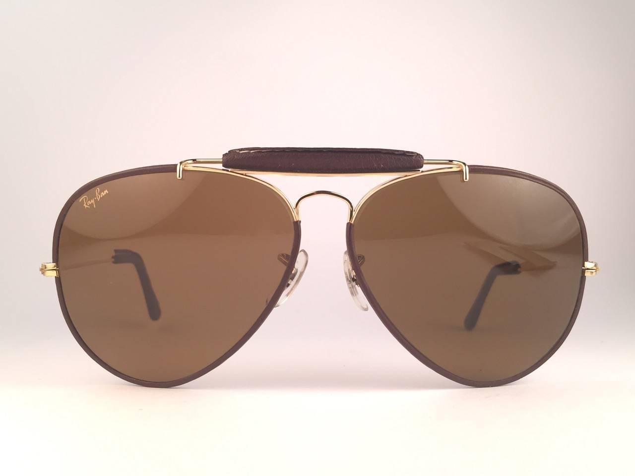 Ray Ban Outdoorsman 62 mm Chocolate Leather with mint B&L B15 brown lenses with golden Ray Ban logo. The left lens has a minor flaw other than that perfection! B&L etched in the lenses, So mid 1970's. 
Original Ray Ban B&L case with