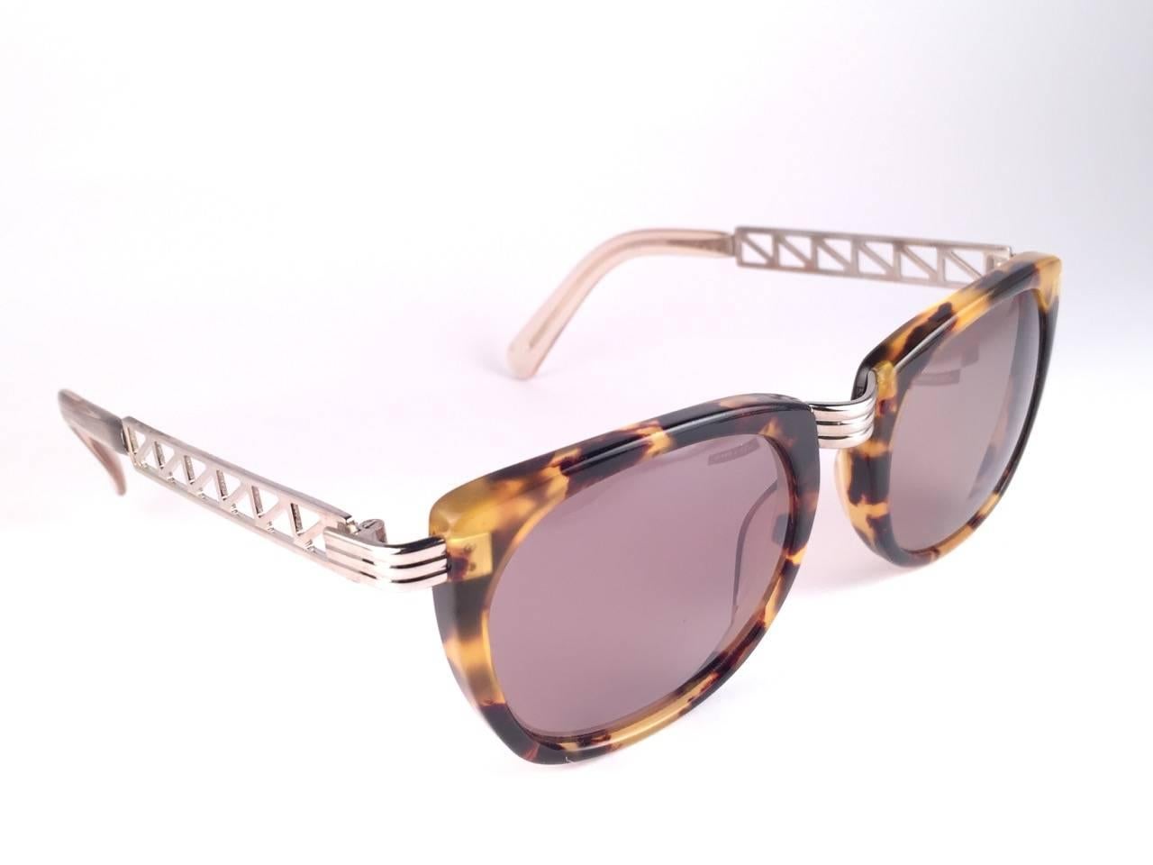 Superb Collectors Item!!
New Jean Paul Gaultier 56 0272 Eiffel Tower Series Silver Ornaments on the temples over sleek tortoise frame. 
Spotless Dark green/ Brown lenses that complete a ready to wear JPG look.

Amazing design with strong yet