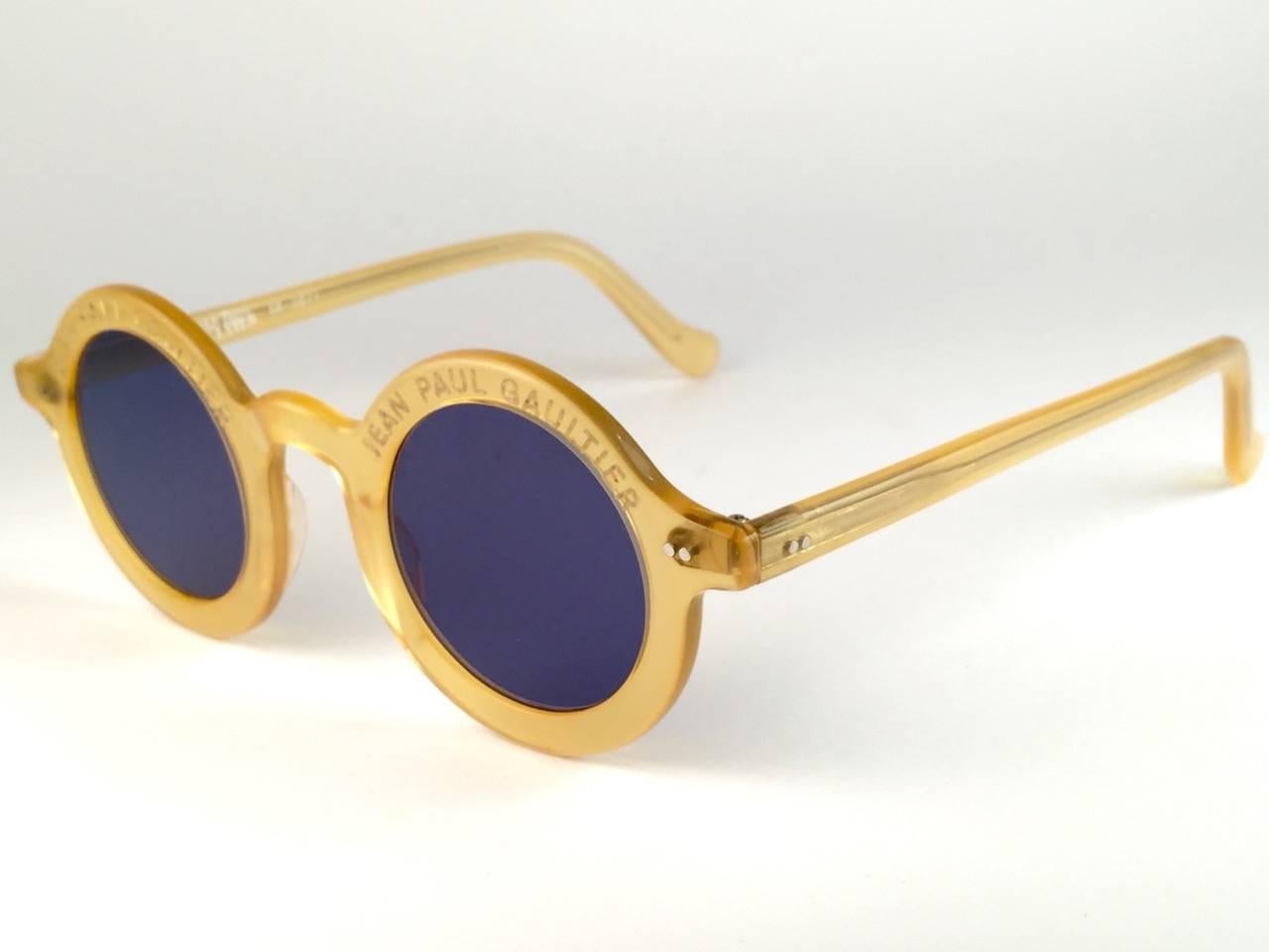 
New Jean Paul Gaultier 56 0071 Iconic round yellow frame. 
Flat blue lenses that complete a ready to wear JPG look.
Amazing quality and design. A piece of sunglasses history.
This pair has small marks due to nearly 30 years of storage. 
Design and