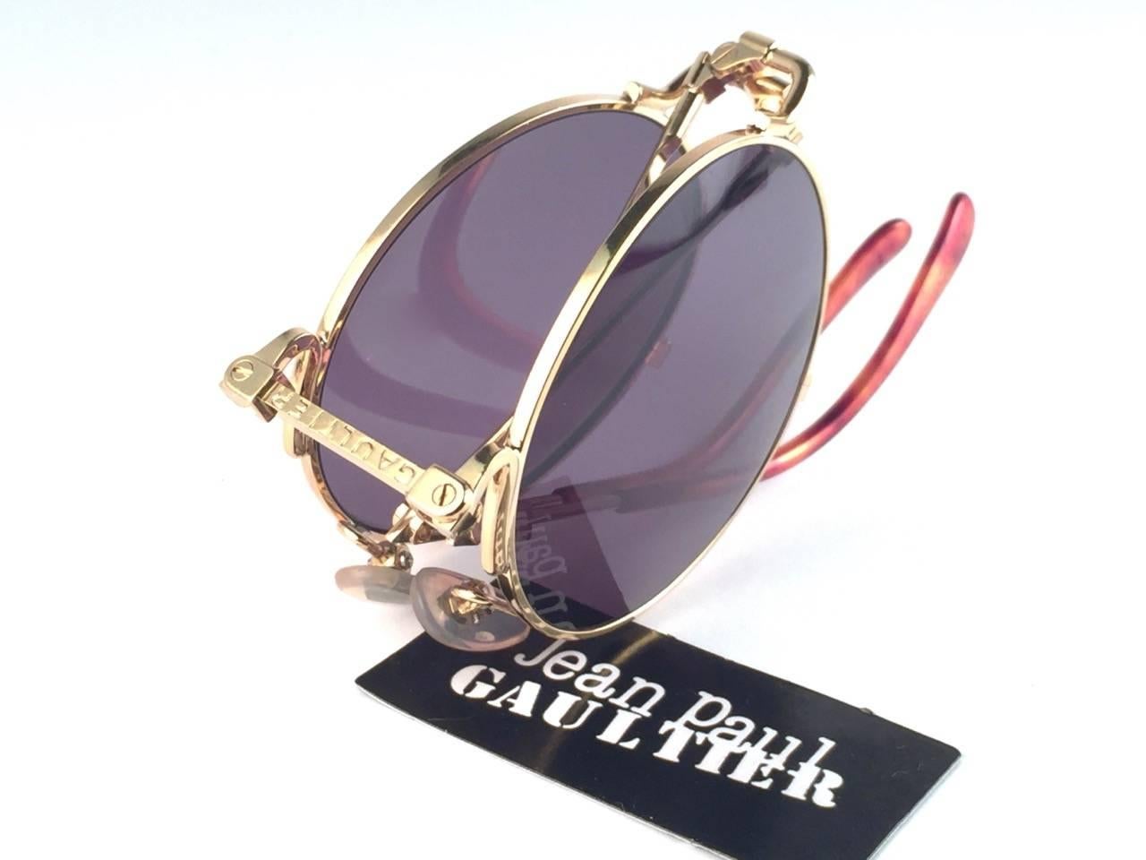 
New Jean Paul Gaultier 56 9171 Round Gold Foldable frame. 
Smoke grey lenses that complete a ready to wear JPG look.

Amazing design with strong yet intricate details.
Design and produced in the 1900's.
New, never worn or displayed.
A true fashion