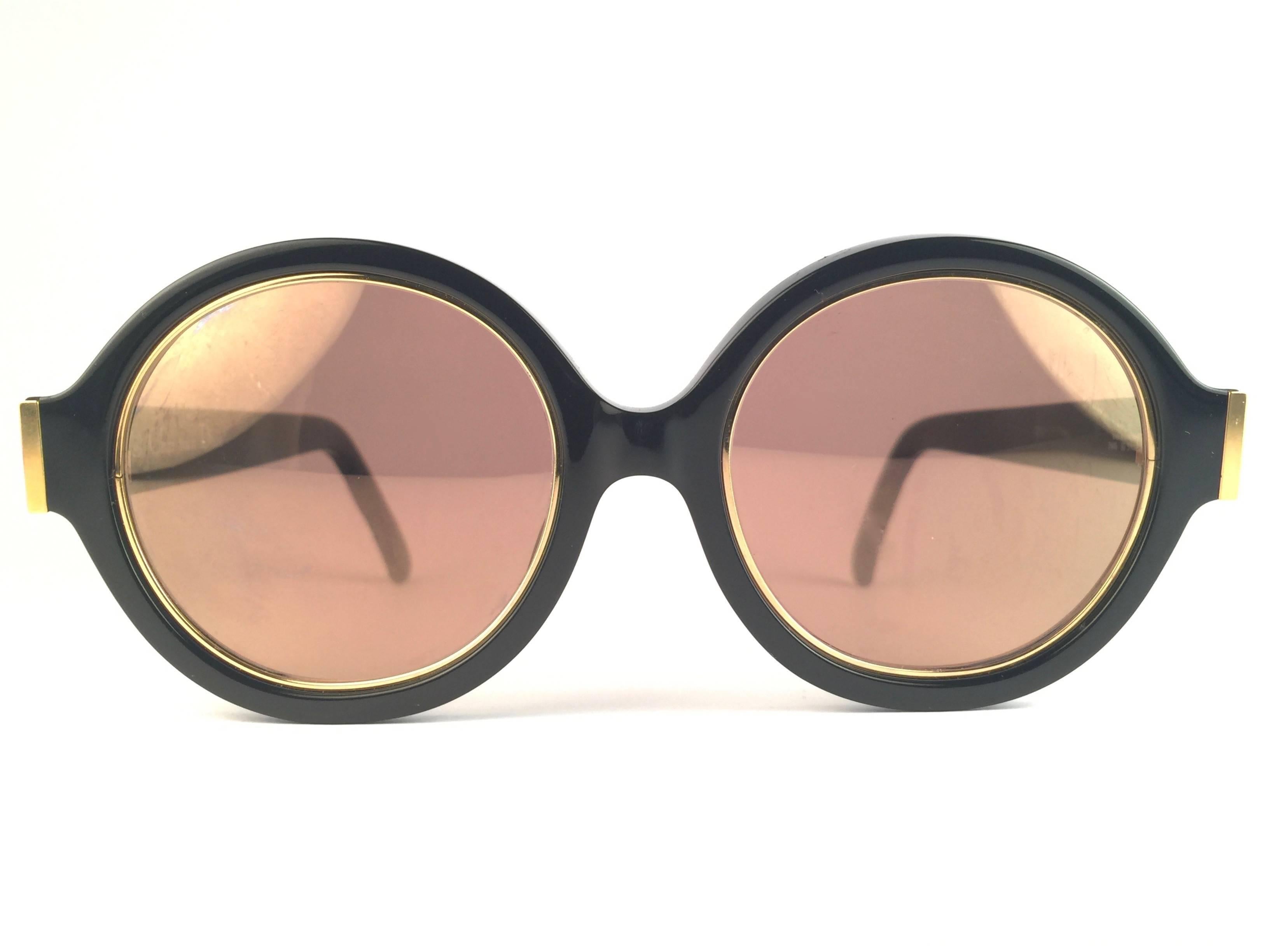 New Vintage Christian Dior 2446 90 Black round with gold inserts frame sporting spotless amber mirror lenses. 

Made in Germany.
 
Produced and design in 1970's.

A collector’s piece!

New, never worn or displayed. Comes with its original silver