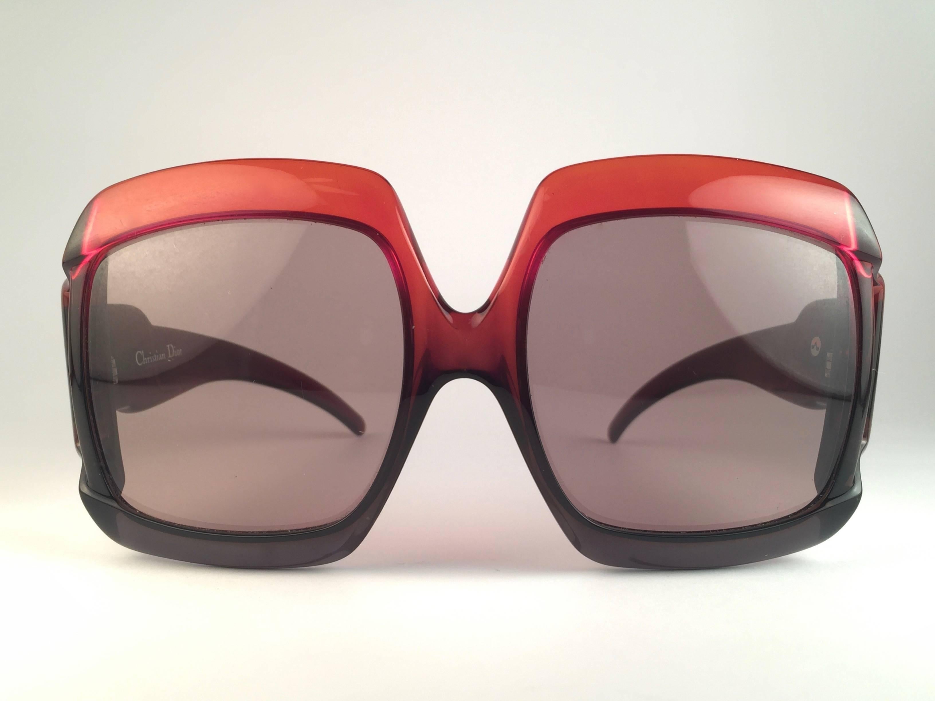 New Vintage Christian Dior D07 Sleek red and black frame sporting spotless medium brown lenses. 

Made in Germany.
 
Produced and design in 1970's.

New, never worn or displayed. Comes with its original silver Christian Dior Lunettes sleeve.