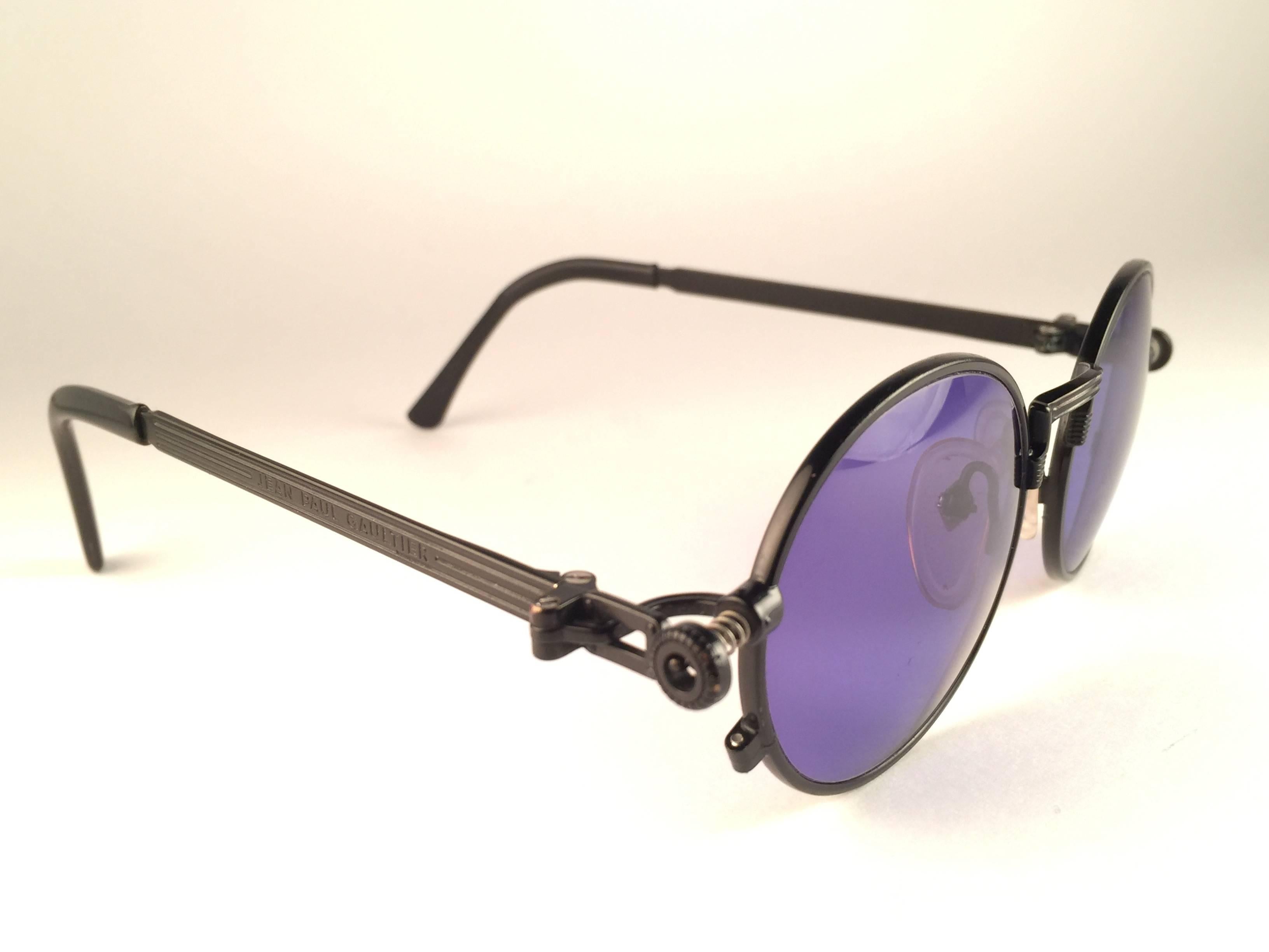 New Jean Paul Gaultier 56 4178 round black matte frame.  
Flat dark purple lenses that complete a ready to wear JPG look.  
Amazing design with strong yet intricate details. 
Design and produced in the 1990's. New, never worn or displayed.
A true