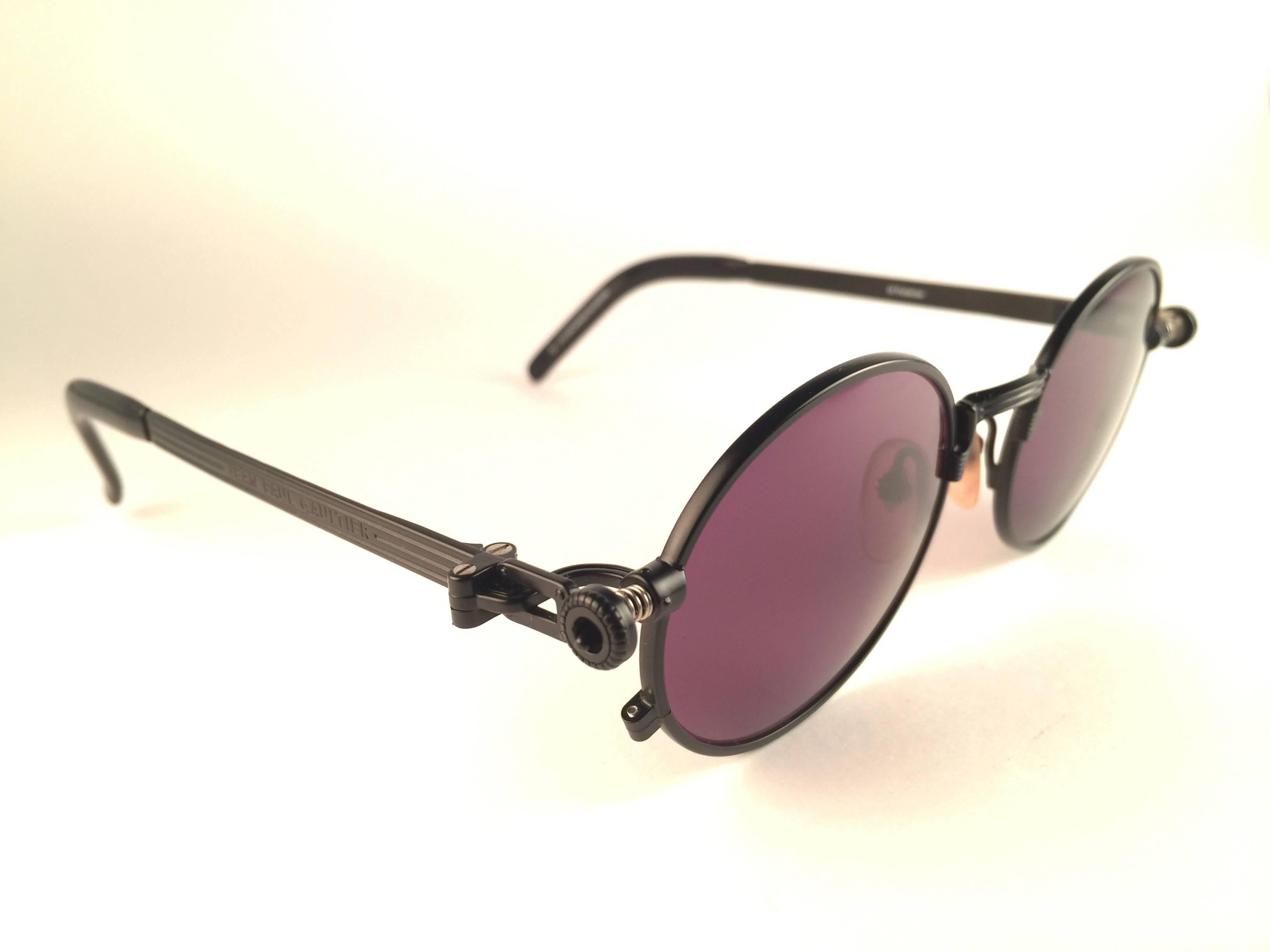 New Jean Paul Gaultier 56 4178 round black matte frame. 
Flat deep brown lenses that complete a ready to wear JPG look. 
Amazing design with strong yet intricate details. 
Design and produced in the 1990's. New, never worn or displayed.
A true