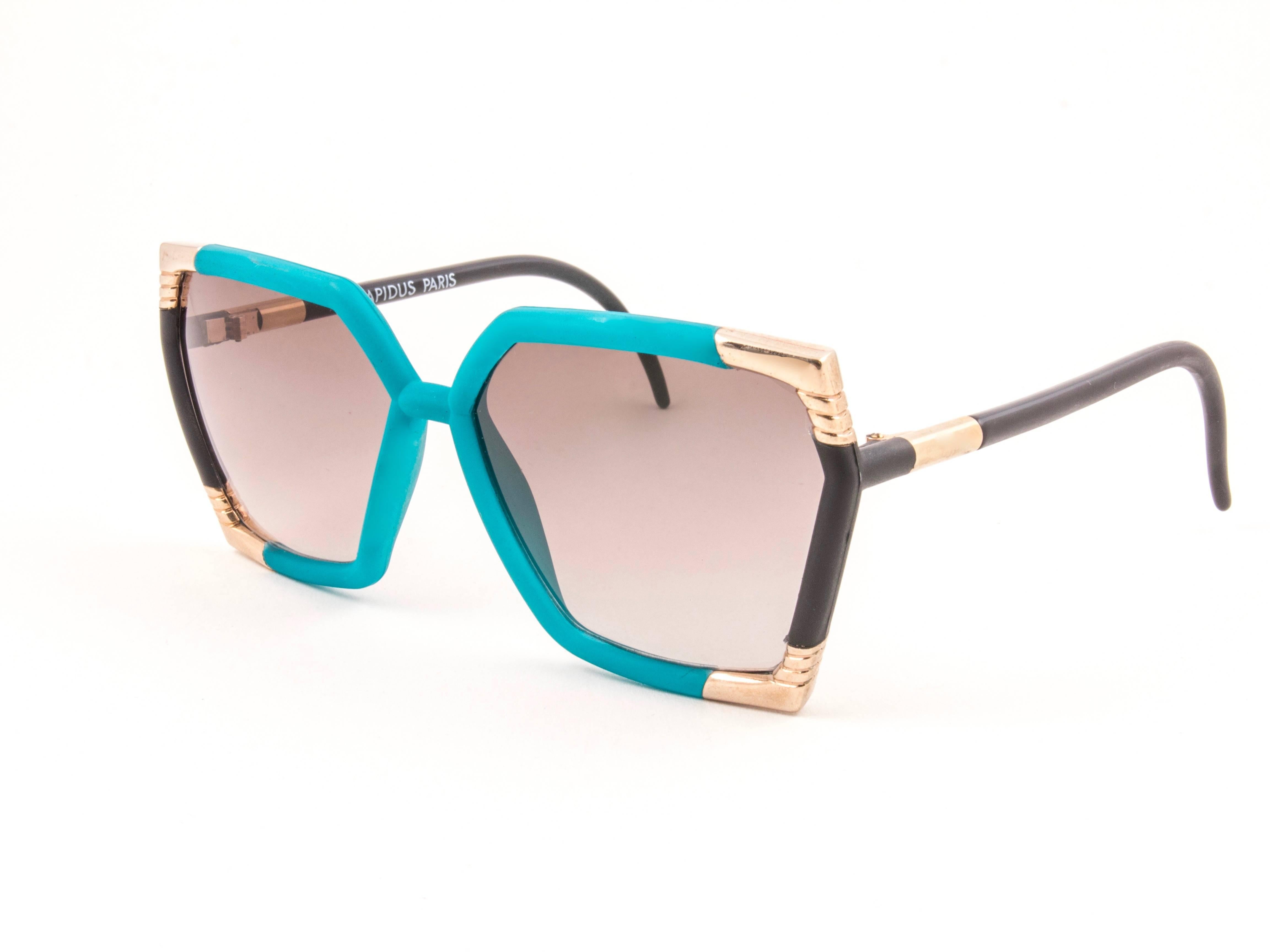 New Vintage Ted Lapidus TL 14 01 Turquoise & gold frame with spotless purple gradient lenses.  
Made in Paris.  
Produced and design in 1970's.  
New, never worn or displayed.