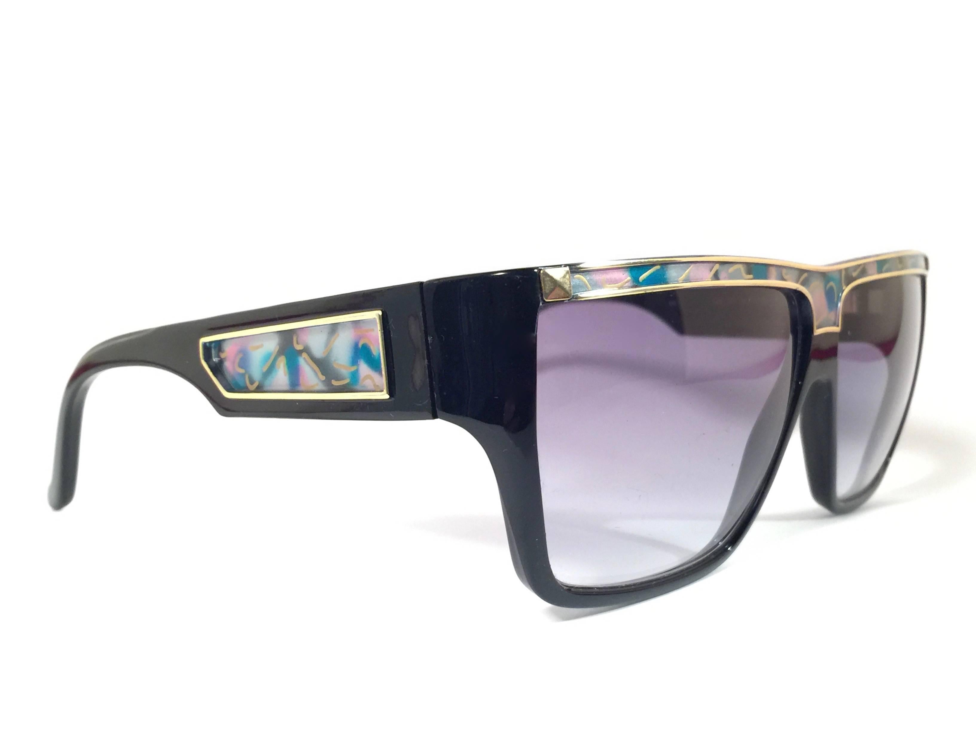 Rare pair of New vintage Leonard sunglasses. 

Black with signature colours mosaic with gold accents frame holding a pair of purple gradient lenses.

New, never worn or displayed. Made in France.
