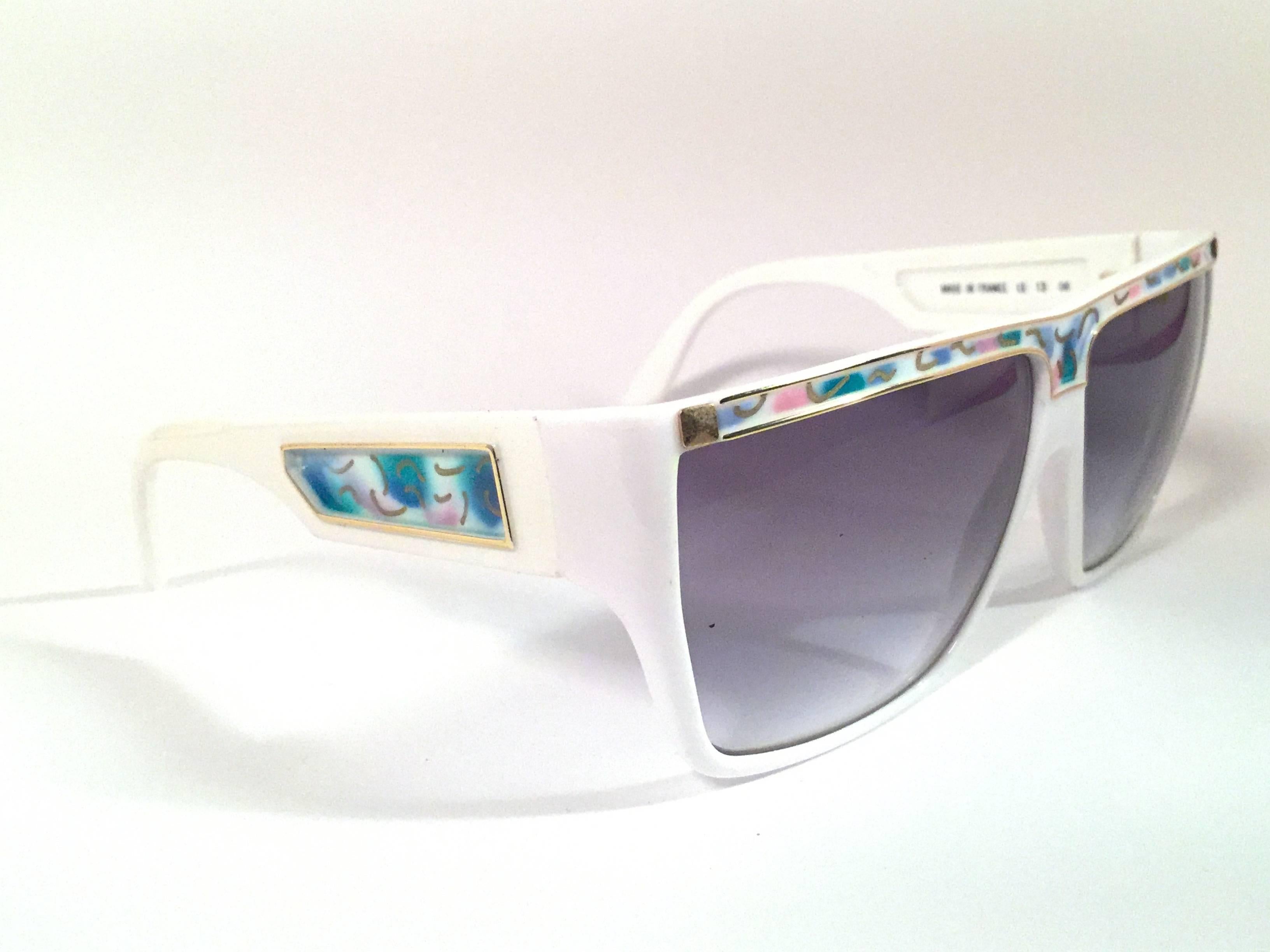 
Rare pair of New vintage Leonard sunglasses. 

White with signature colours mosaic with gold accents frame holding a pair of mint purple lenses.

New, never worn or displayed. Made in France.
