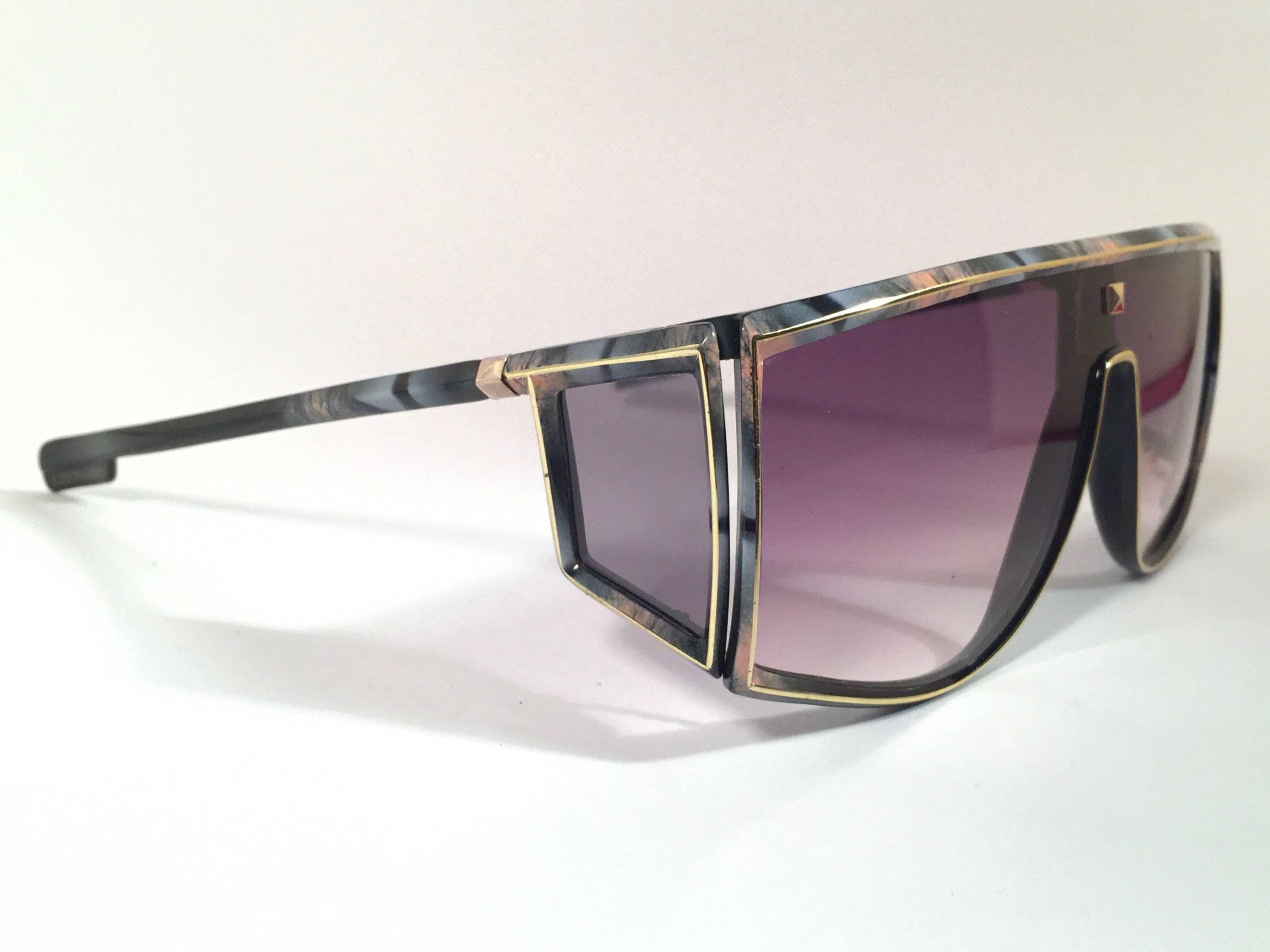 Rare pair of New vintage Leonard sunglasses.   
Sleek black with signature colours mosaic with gold accents mask frame holding a pair of rose gradient lenses.  
New, never worn or displayed. 
Made in France.
