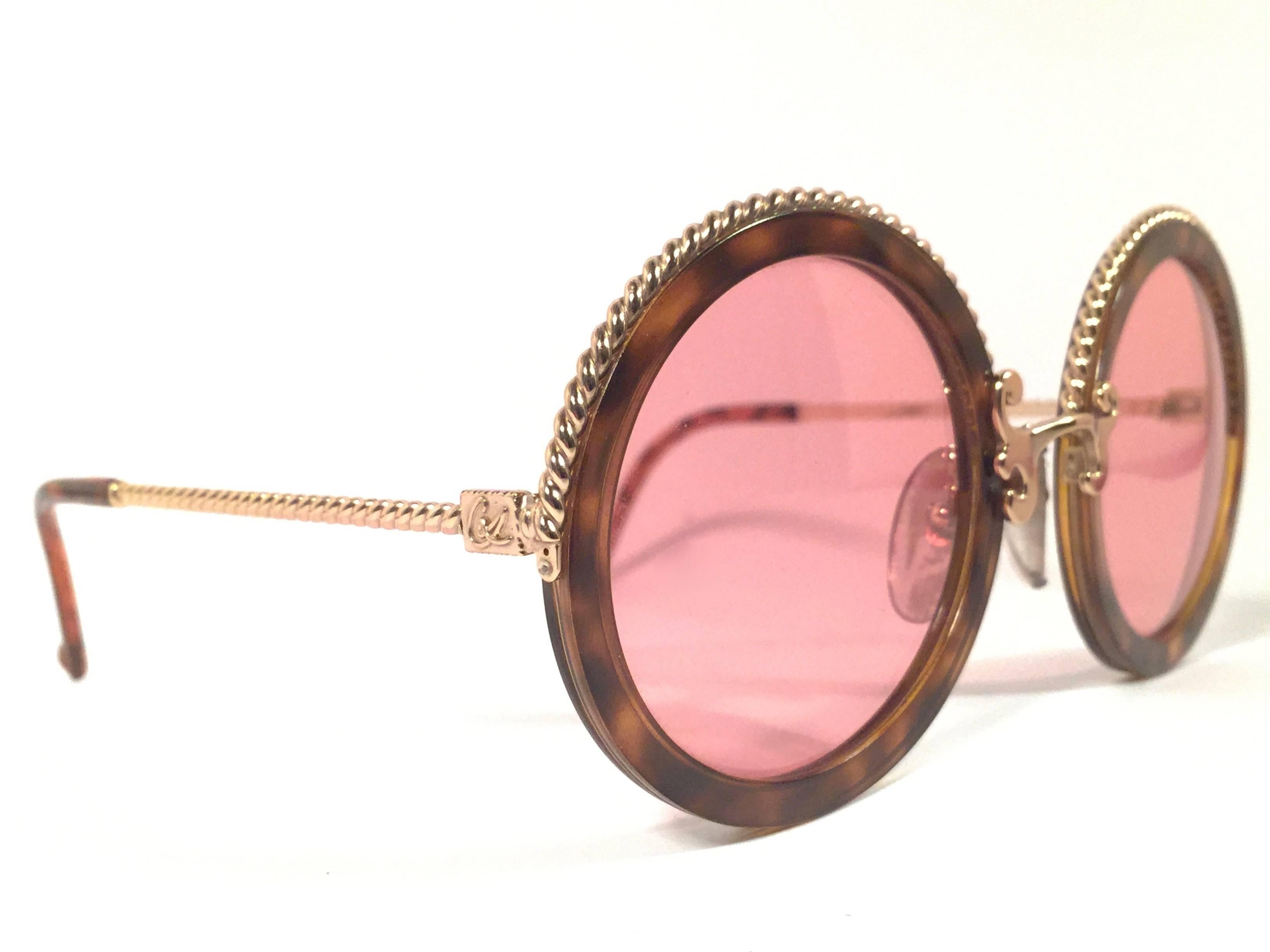 Superb & rare pair of New vintage Christian Lacroix sunglasses. 

Tortoise round with delicate gold accents frame holding a pair of spotless amber lenses. 

New, never worn or displayed. Made in France.