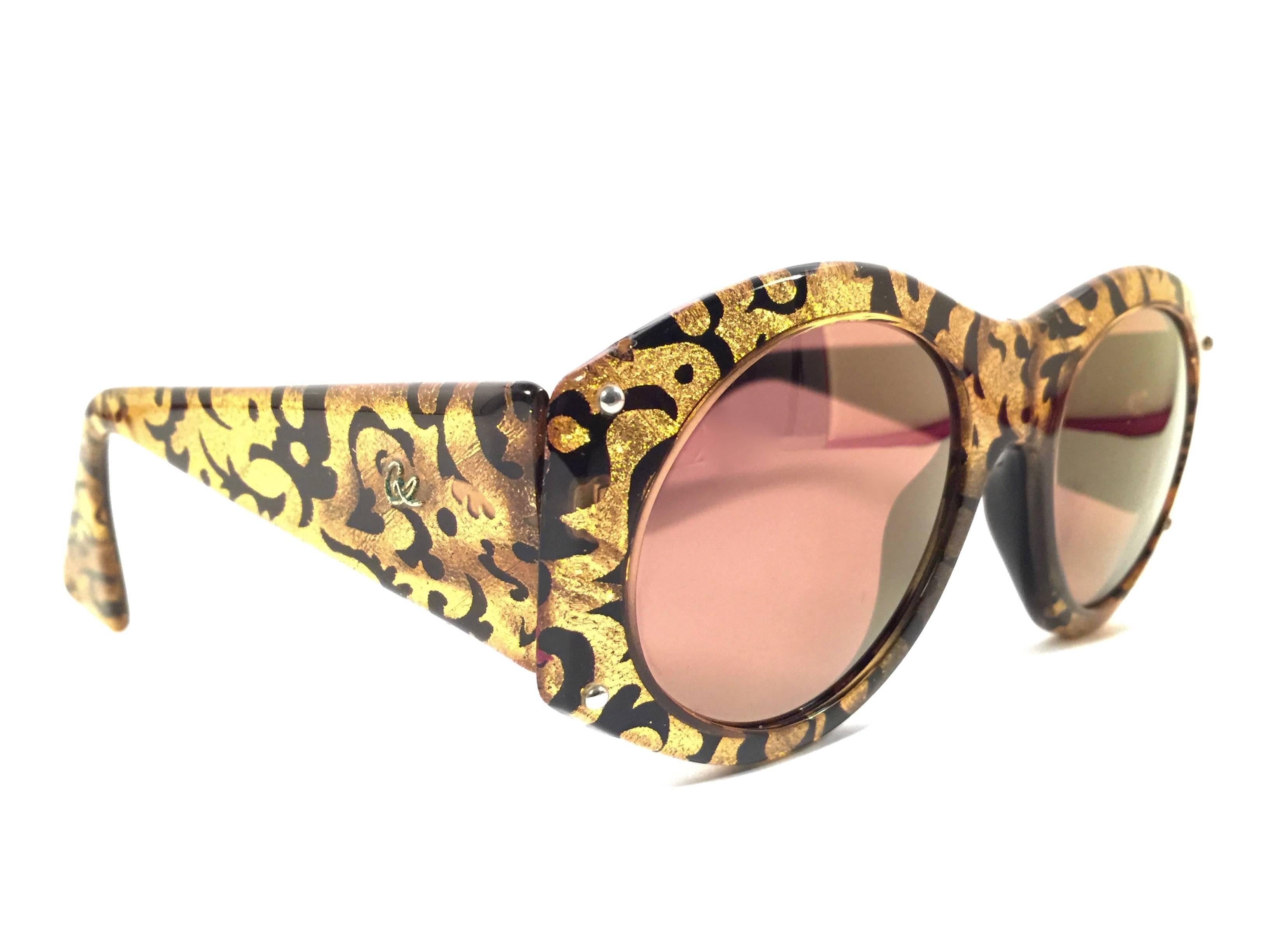 Rare pair of New vintage Christian Lacroix sunglasses.   

Black & gold baroque pattern frame holding a pair of spotless amber mirror lenses. The interior logo has fade due to storage.

New, never worn or displayed. 

Made in France.

FRONT : 14.5