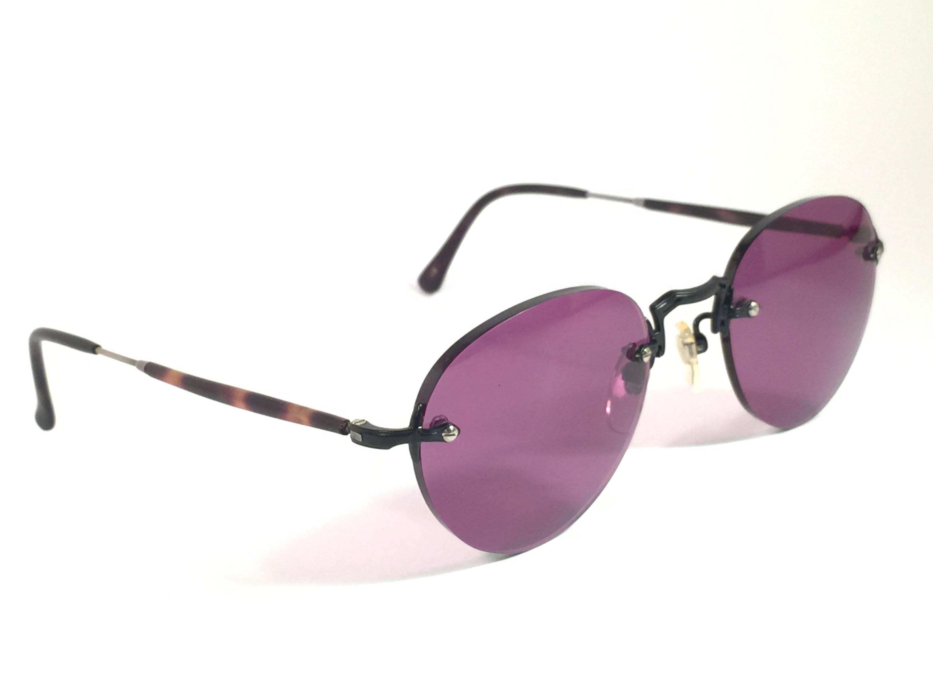 Cult brand Matsuda signed this ultra chic pair of black oval rimless with tortoise temples sunglasses. 

Spotless dark purple lenses.

Superior quality and design. 

New, never worn or displayed. Made in japan.
