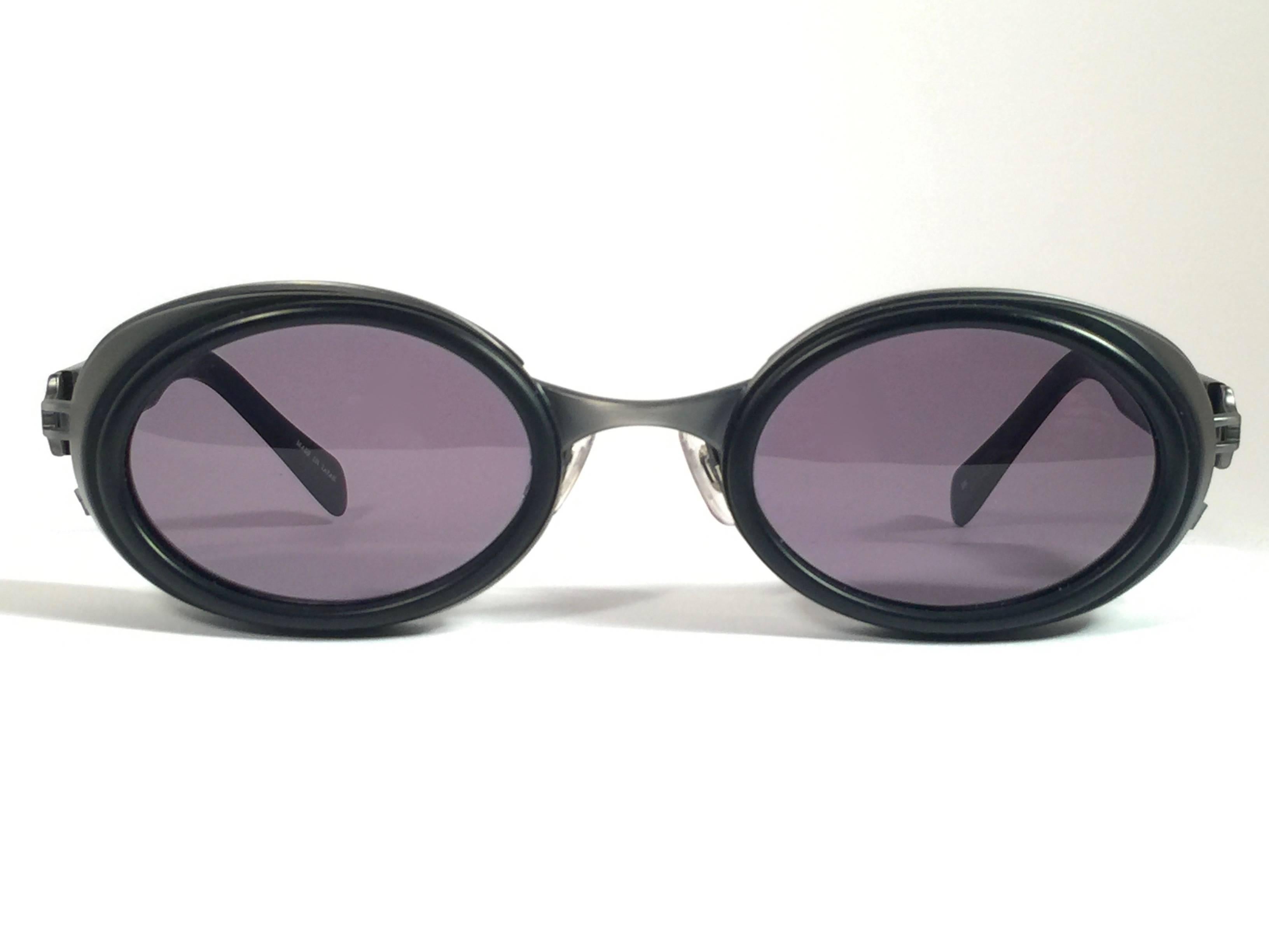Die Kultmarke Matsuda hat diese ultra-schicke ovale Sonnenbrille in mattem Schwarz mit silbernen Akzenten entworfen. 

Makellose graue G15-Gläser.

Hervorragende Qualität und Design. 

Neu, nie getragen oder ausgestellt. Hergestellt in