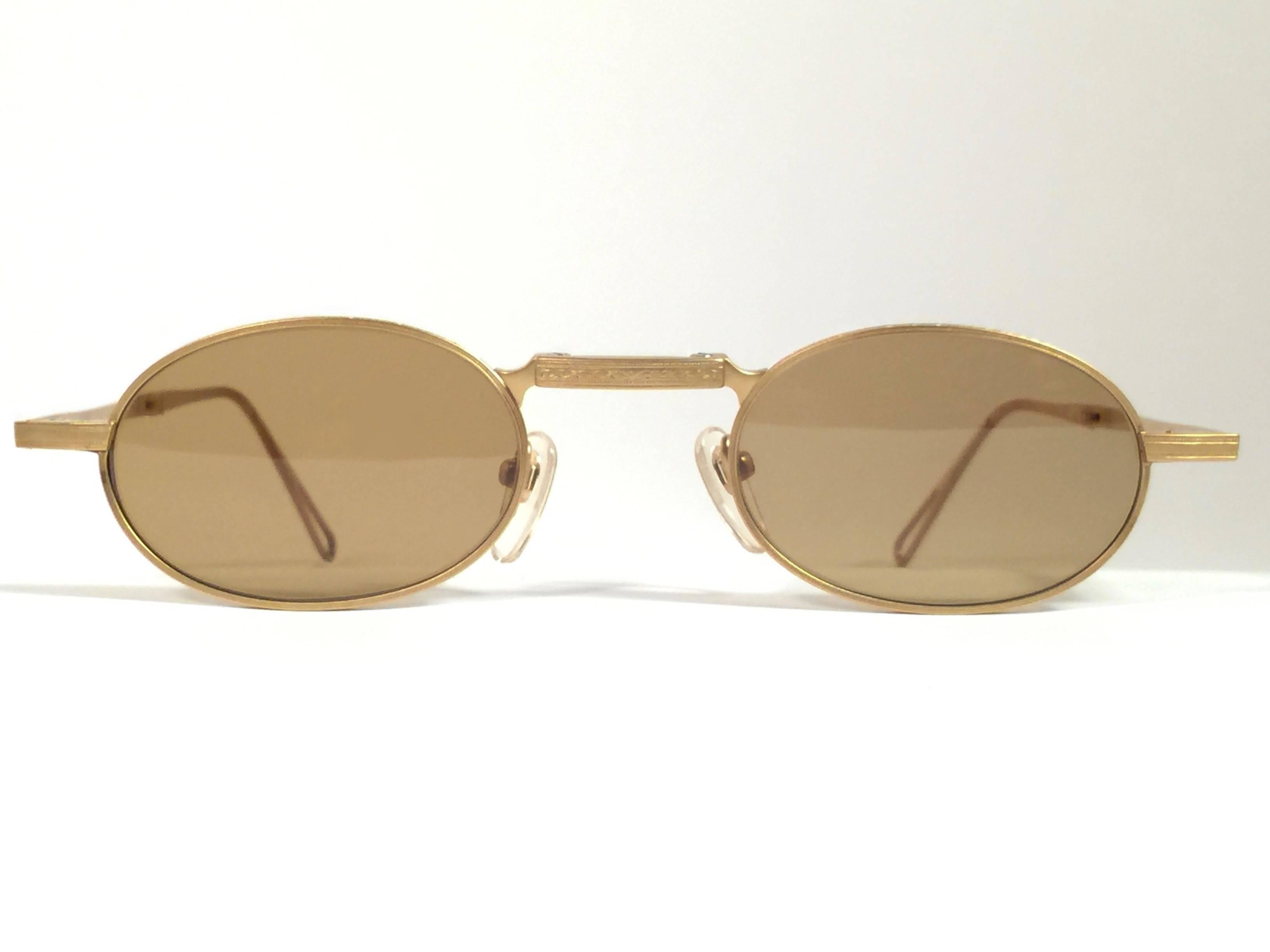 Cult brand Matsuda signed this ultra chic pair of oval folding gold matte sunglasses. 

Spotless medium brown lenses.

Superior quality and design. 

New, never worn or displayed. Made in japan. 
This item may show minor sign of wear due to
