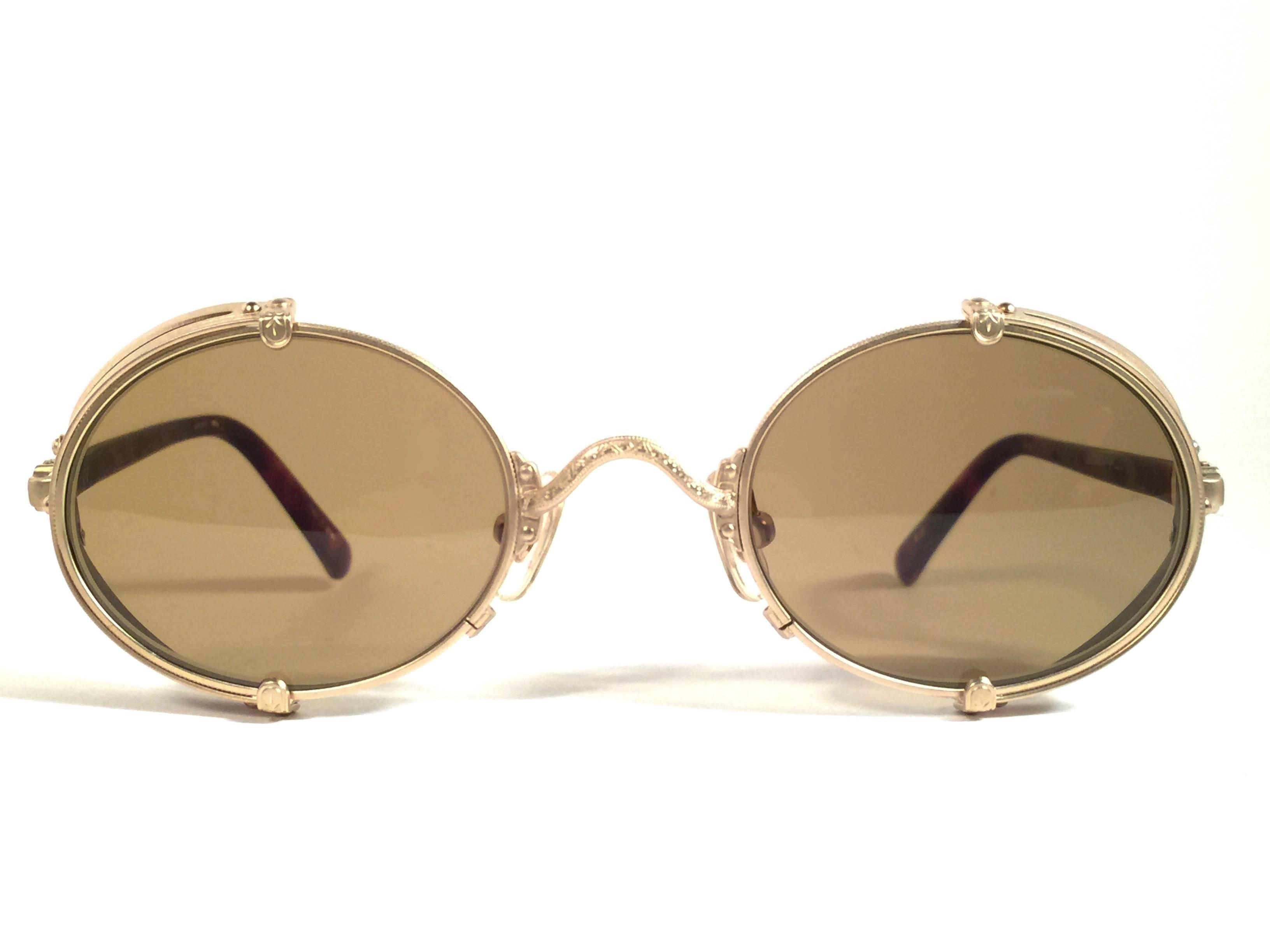 Cult brand Matsuda signed this ultra chic pair of round gold matte with brown side cups sunglasses.   
Spotless brown medium lenses.  
Superior quality and design.   
New, never worn or displayed. Made in japan.