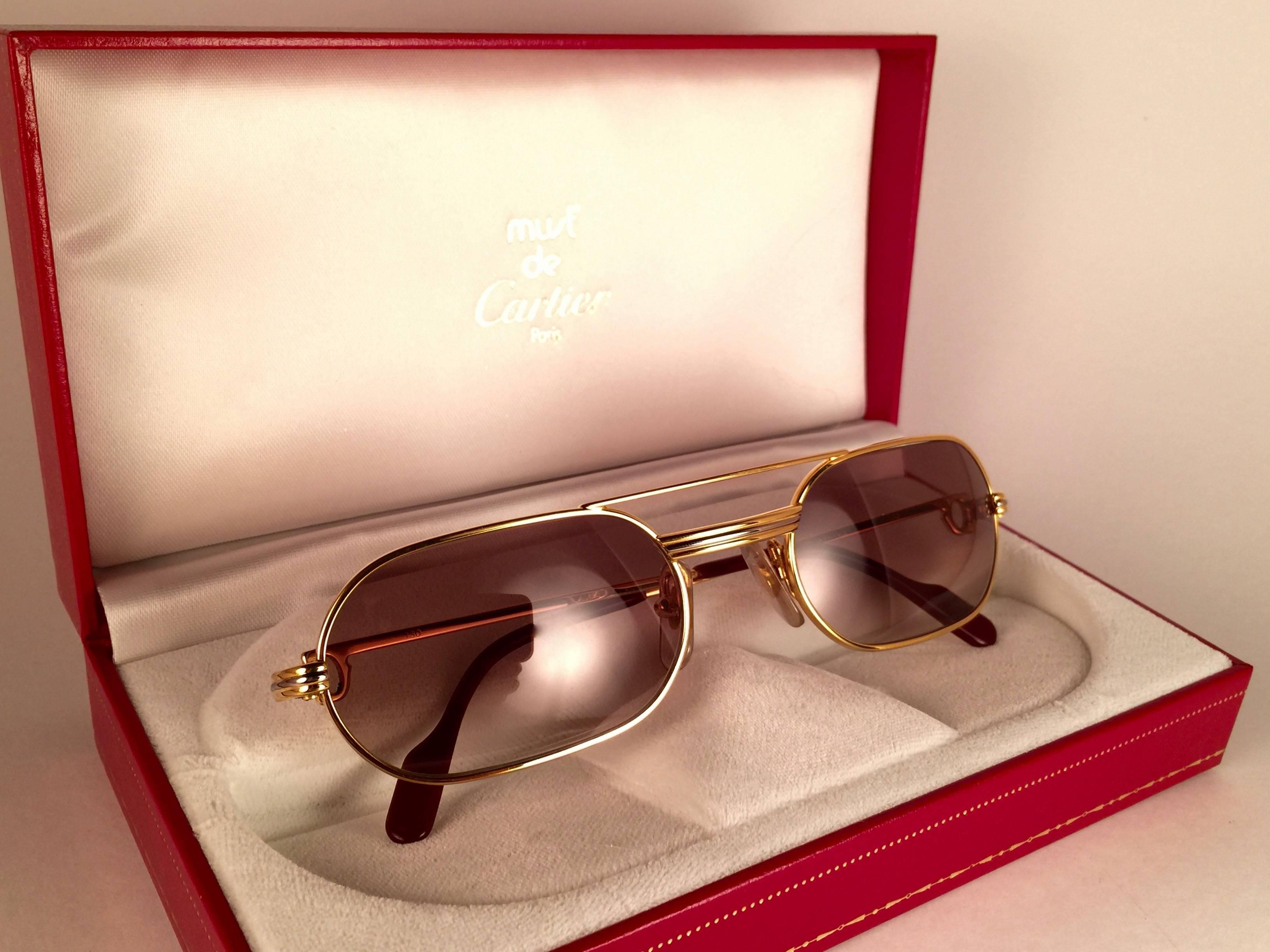 Gafas de sol Cartier Louis Cartier Vendome originales de 1983 con cristales nuevos de color marrón miel. El marco es con el anverso y los laterales en oro amarillo y blanco y los famosos acentos Vendome.  
Todos los sellos. esmalte rojo con signos