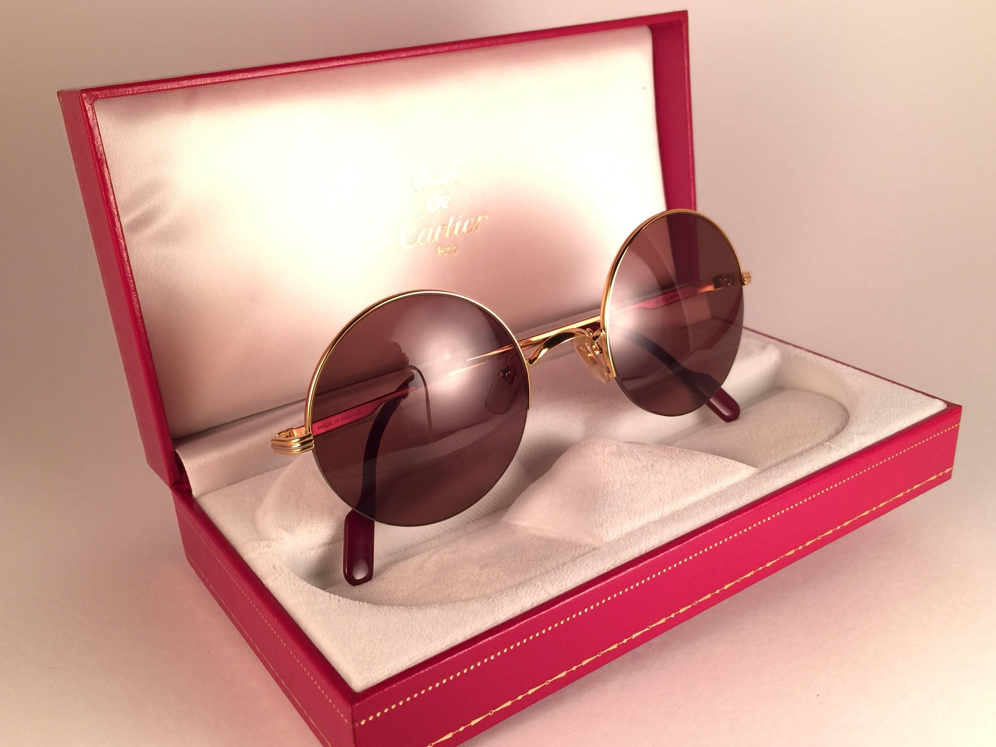 New 1990 Cartier Mayfair half frame sunglasses with brown (uv protection) lenses.  Frame is with the front and sides in gold. All hallmarks. Cartier gold signs on the ear paddles.  These are like a pair of jewels on your nose. Beautiful design and a