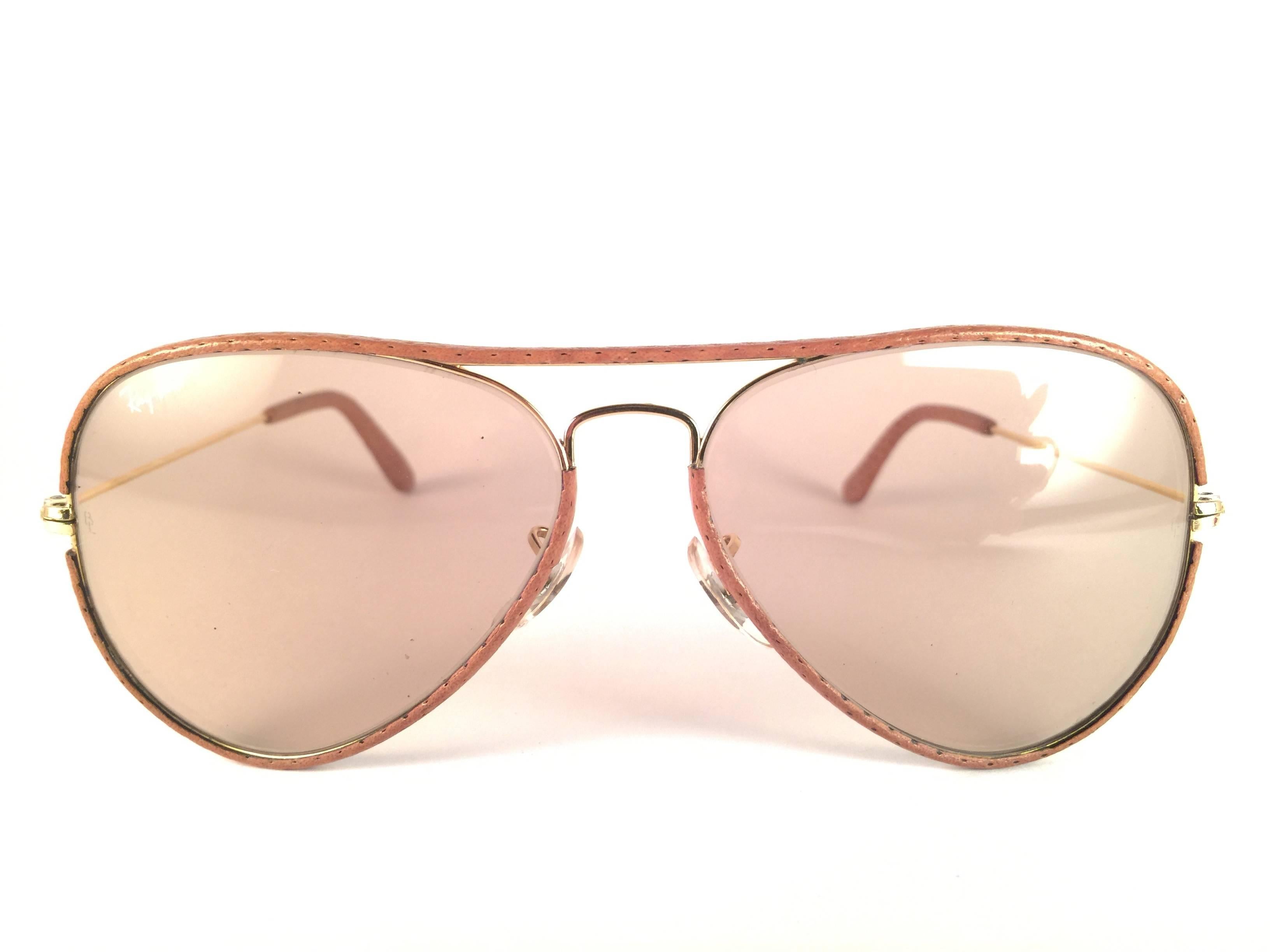 New Vintage Ray Ban Leathers Aviator 58mm in perforated beige leather with gold metal combination frame sporting light changeable to brown lenses with white Ray Ban logo.   B&L etched in the lenses, so mid 1970's.   Comes with its original Ray Ban