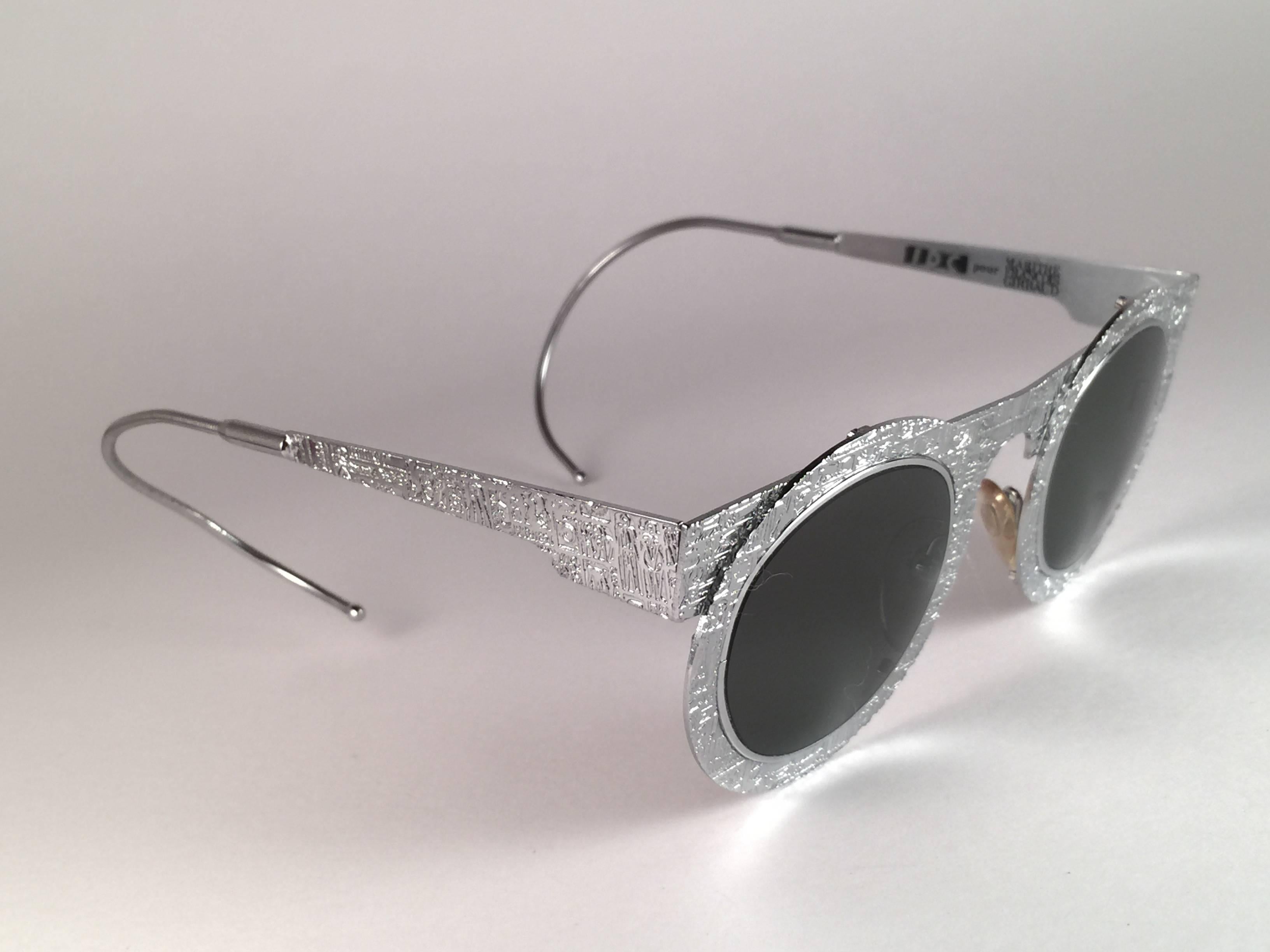 

IDC Pour Marithe Francois Girbaud round silver with engraved accents sunglasses holding a spotless pair of G15 grey lenses. Curled temples for a fashionable yet comfortable wear.

New, never worn or displayed. Made in France.
