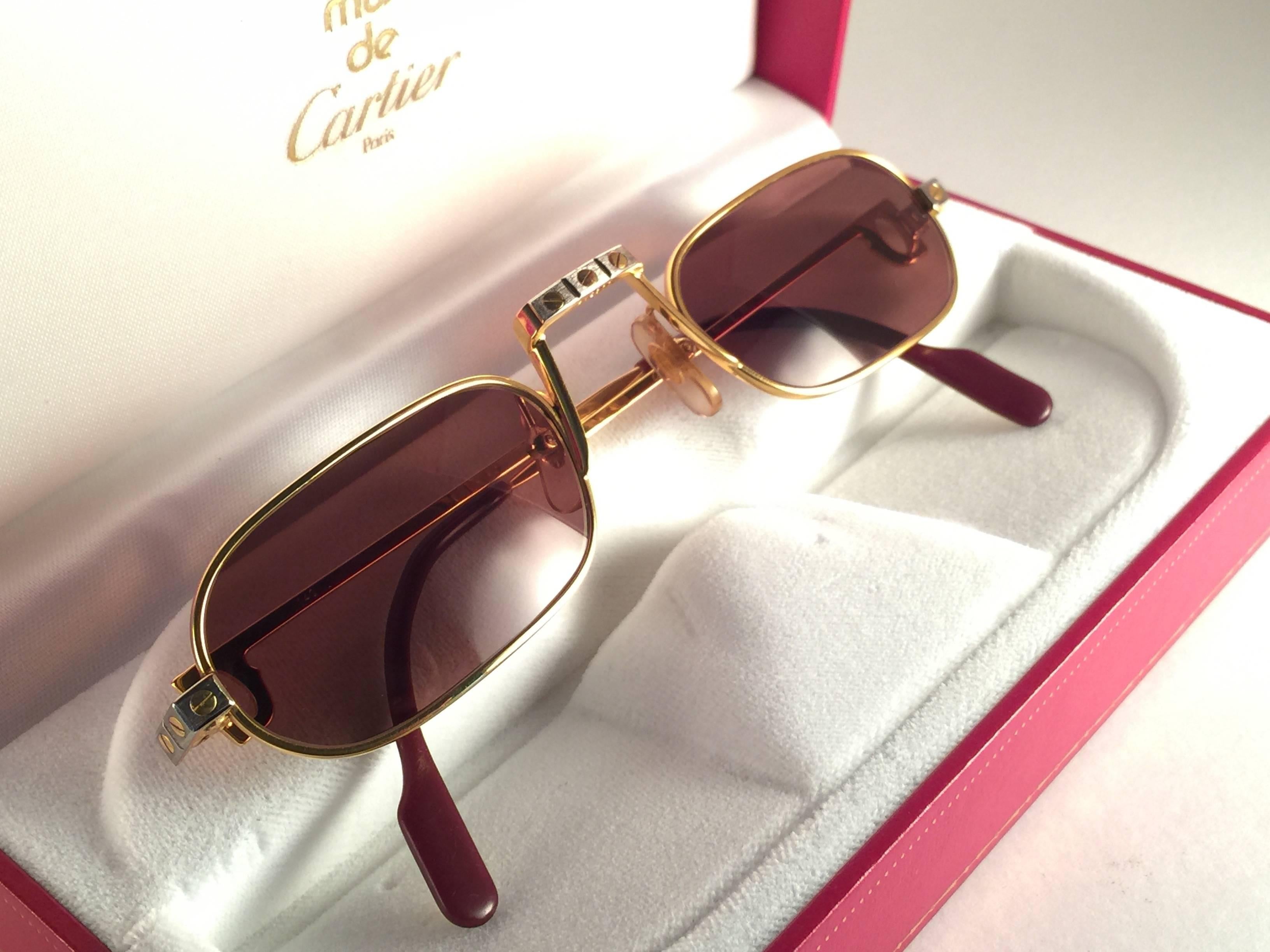 New Vintage Cartier Louis Santos demi lune sunglasses with new honey brown lenses. Perfect and fit for reading glasses. Frame is with the front and sides in yellow and white gold and the famous screws.
All hallmarks. Red enamel with Cartier gold