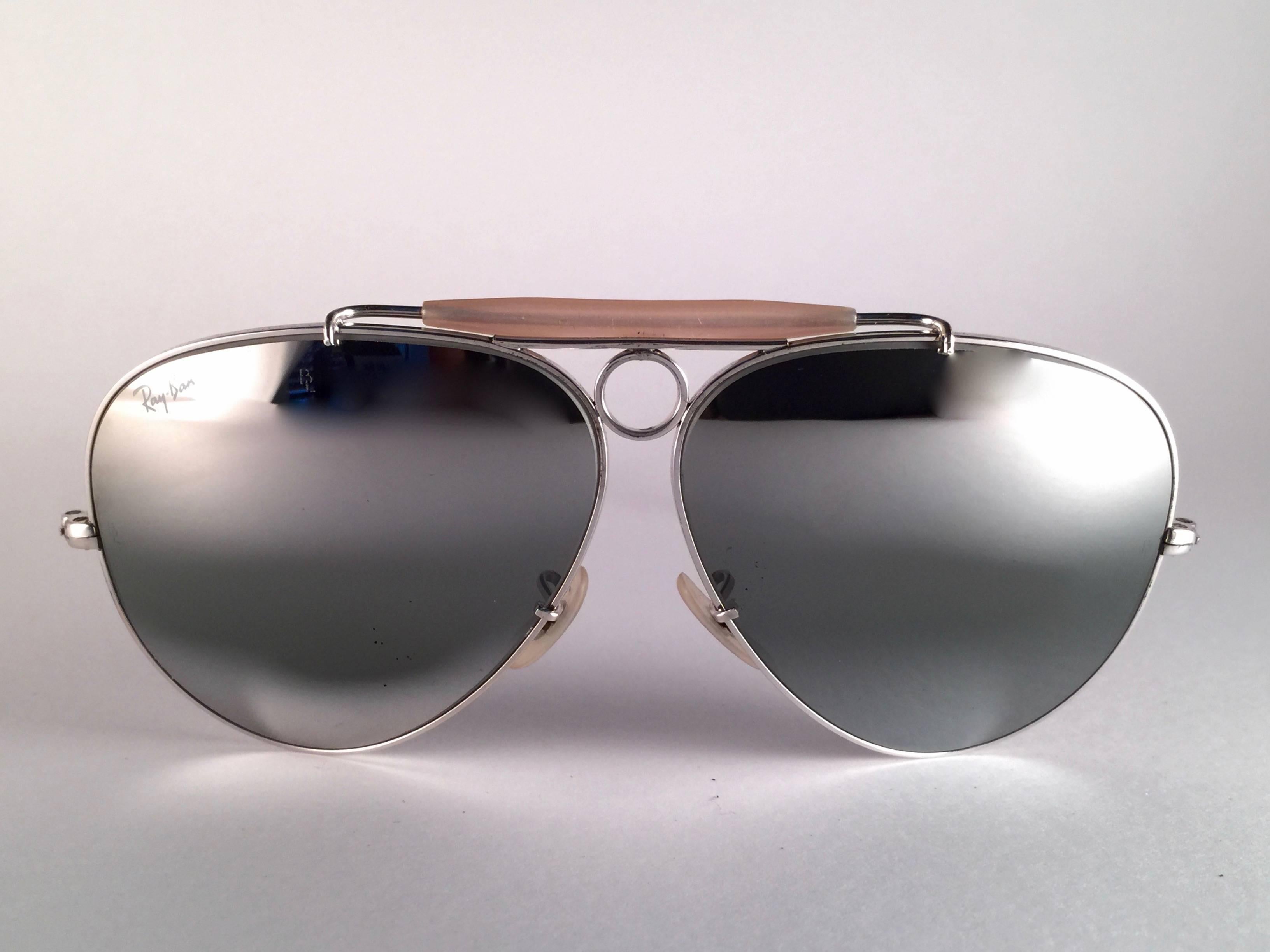 New Vintage Ray Ban Shooter White Gold 62mm with double mirror lenses.  B&L etched twice in both lenses.  
Comes with its original Ray Ban B&L case.  
A seldom piece in new, never worn or displayed condition.