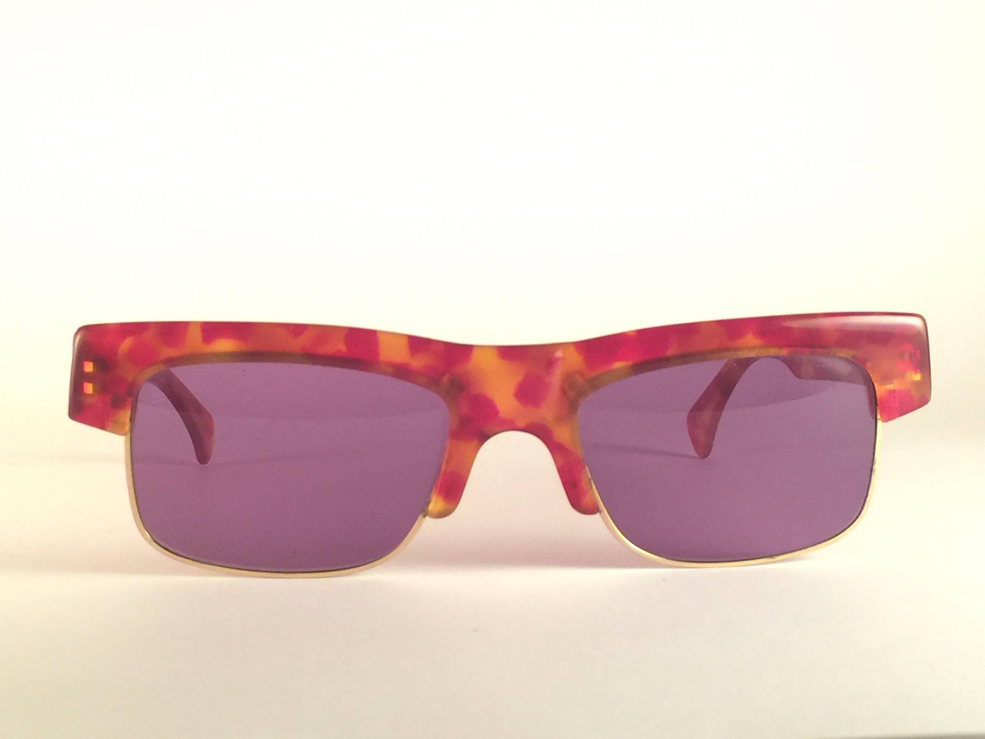 New Vintage Alain Mikli in Tortoise with gold accents frame.

Rare item in new and unworn condition. Spotless purple lenses.

Please consider that this item is nearly 40 years old so it could show minor sign of wear due to storage.

Comes with its