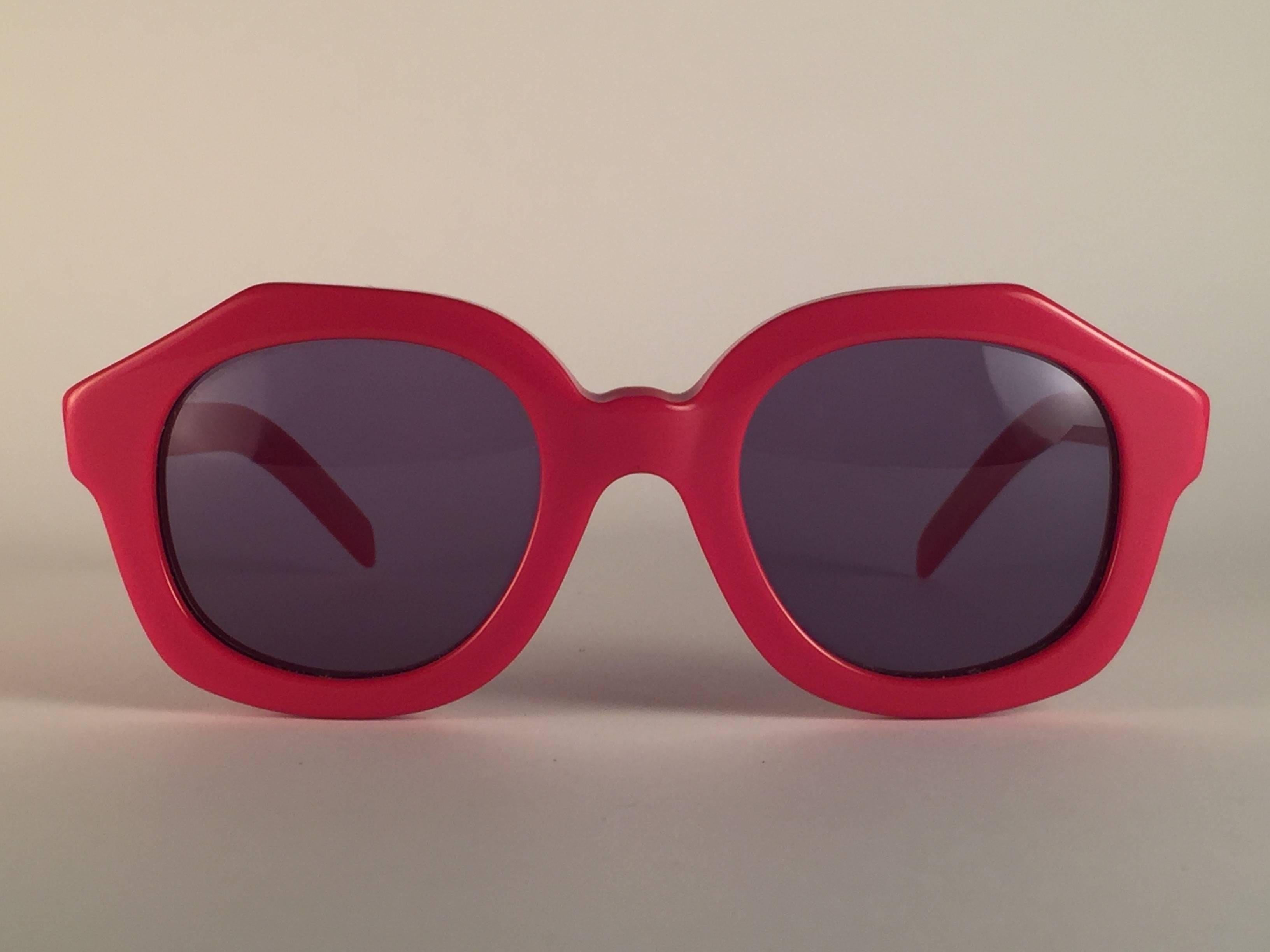 New Vintage Alain Mikli candy red frame.

Rare item in new and unworn condition. Spotless dark grey lenses.

Please consider that this item is nearly 40 years old so it could show minor sign of wear due to storage.

Comes with its original Alain