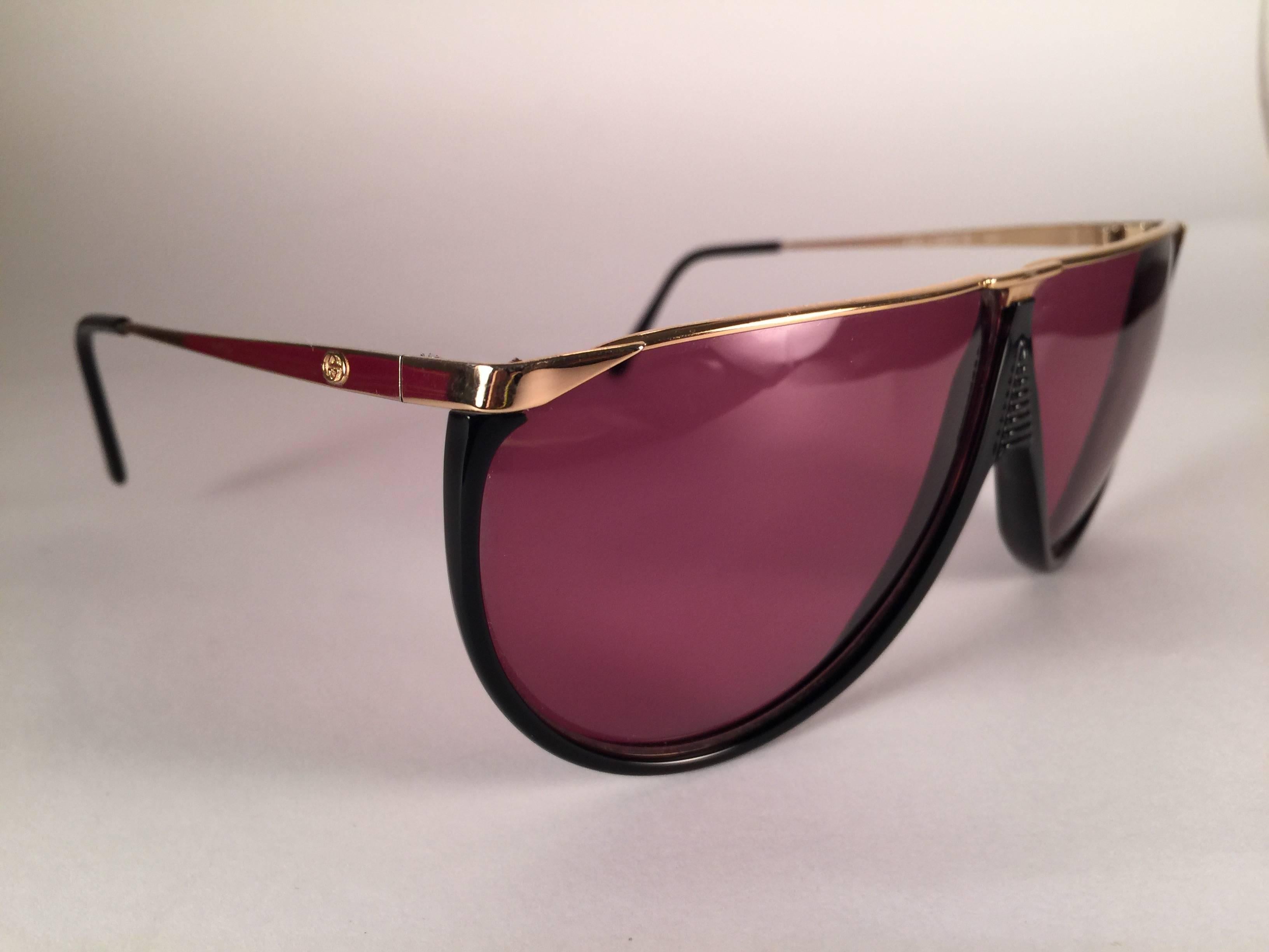 New Vintage Gucci Sunglasses in sleek black with gold details frame.
Spotless purple lenses. 
New never worn or displayed. This item could show minor sign of wear due to nearly 30 years of storage.
Made in Italy.