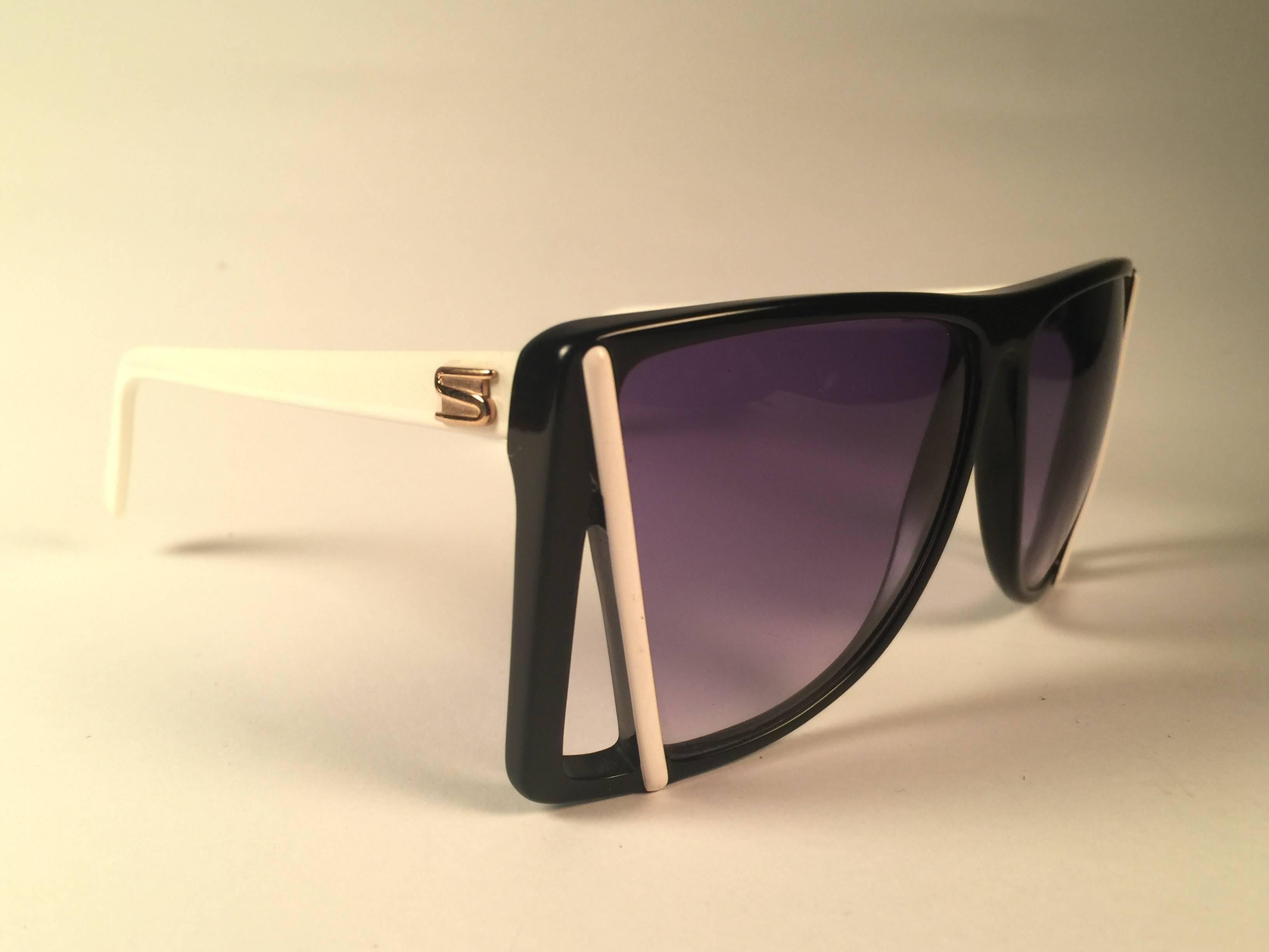 New Vintage Silhouette black with white accents sunglasses. Cut out frame sporting a pair of purple lenses.

Never worn or displayed. This item may show minor sign of wear due to nearly 40 years of storage.

Designed and produced in Austria.