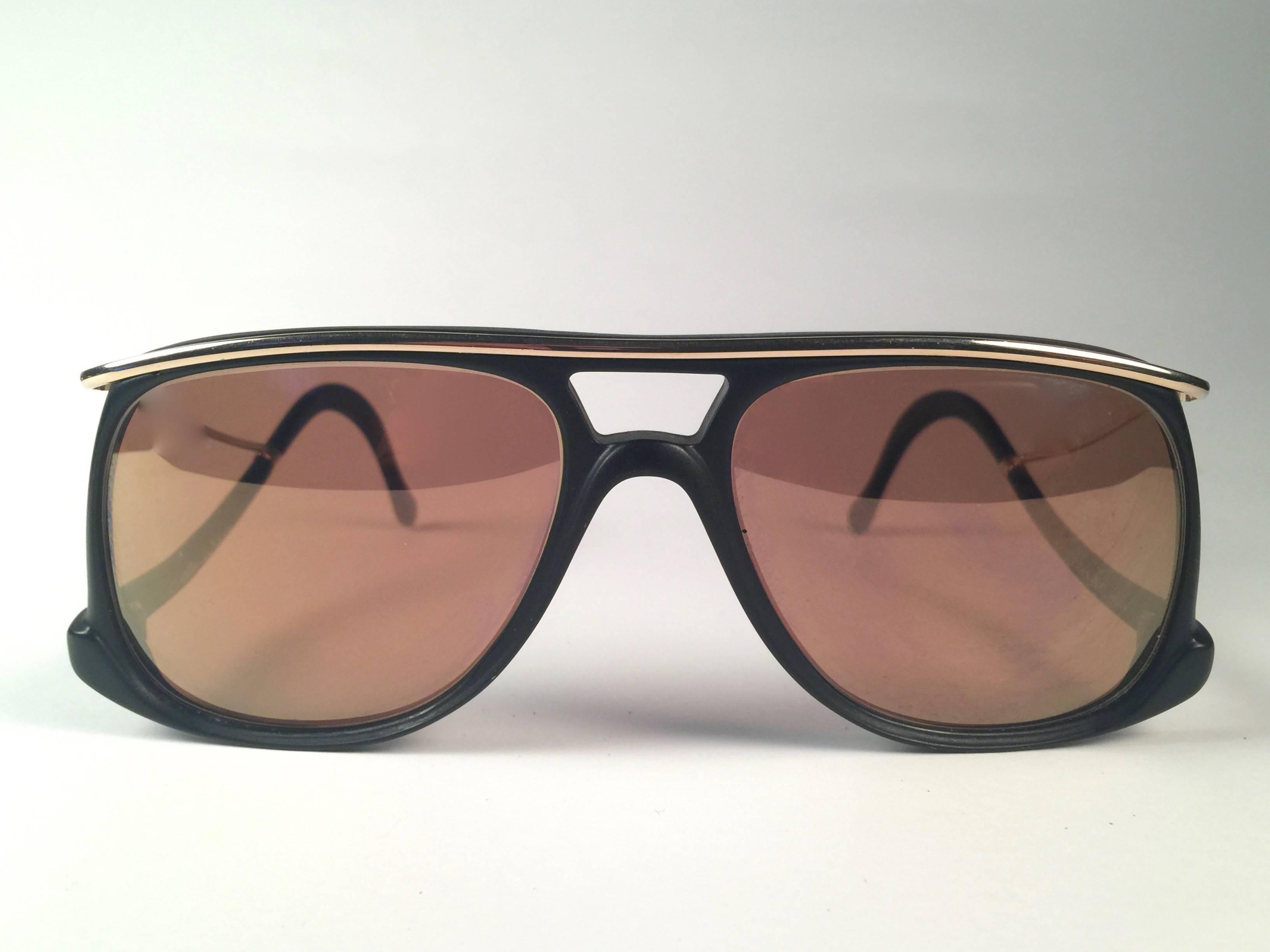 New Vintage Colani Design black matte with gold accents sunglasses. Cut out frame sporting a pair of gold mirror lenses.

Never worn or displayed. This item may show minor sign of wear due to nearly 40 years of storage.

Designed and produced in