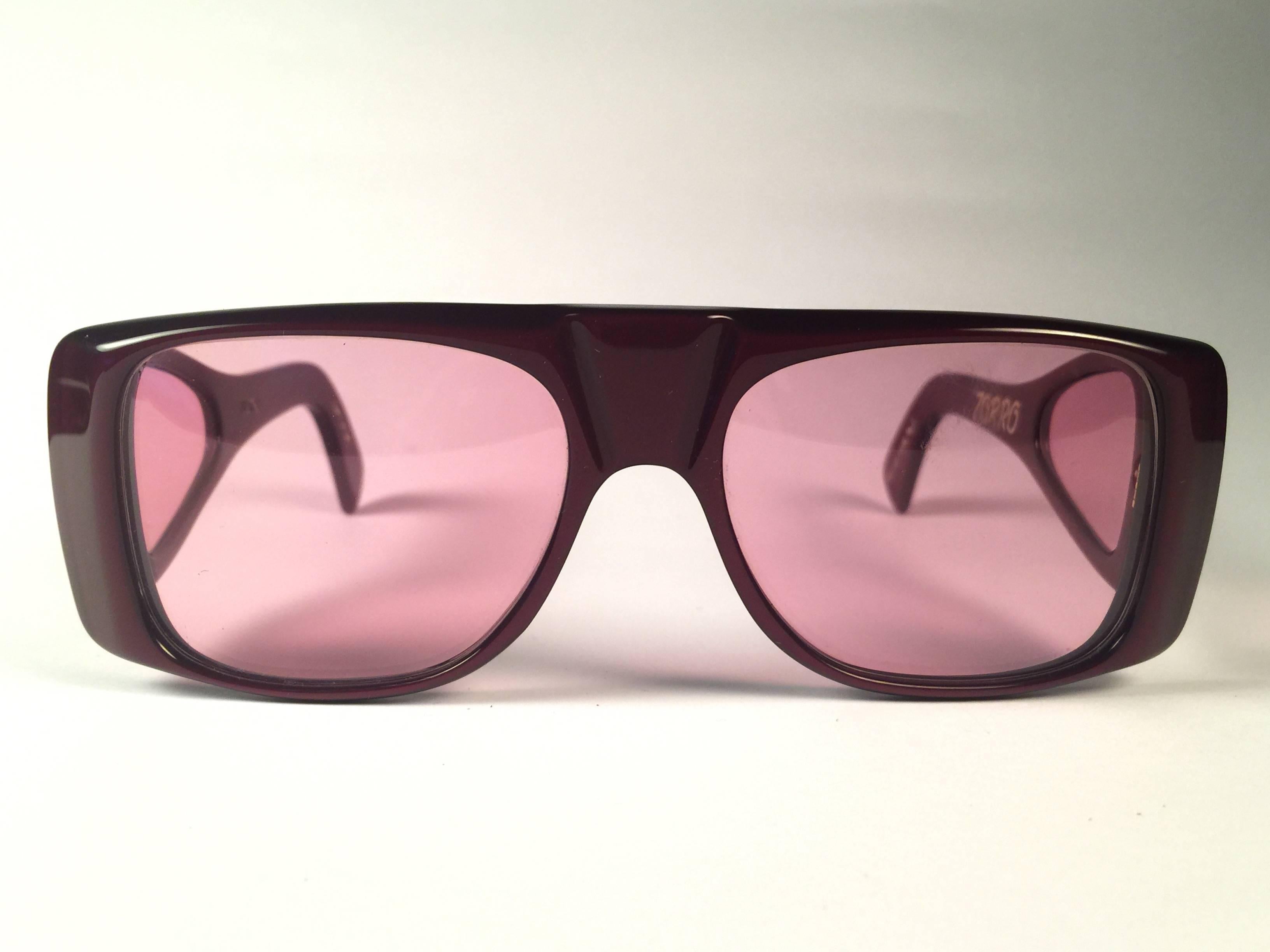 New Vintage Ultra " Zorro " in burgundy sunglasses. Cut out frame sporting a pair of rose lenses.

Never worn or displayed. This item may show minor sign of wear due to nearly 40 years of storage.

Designed and produced in England.