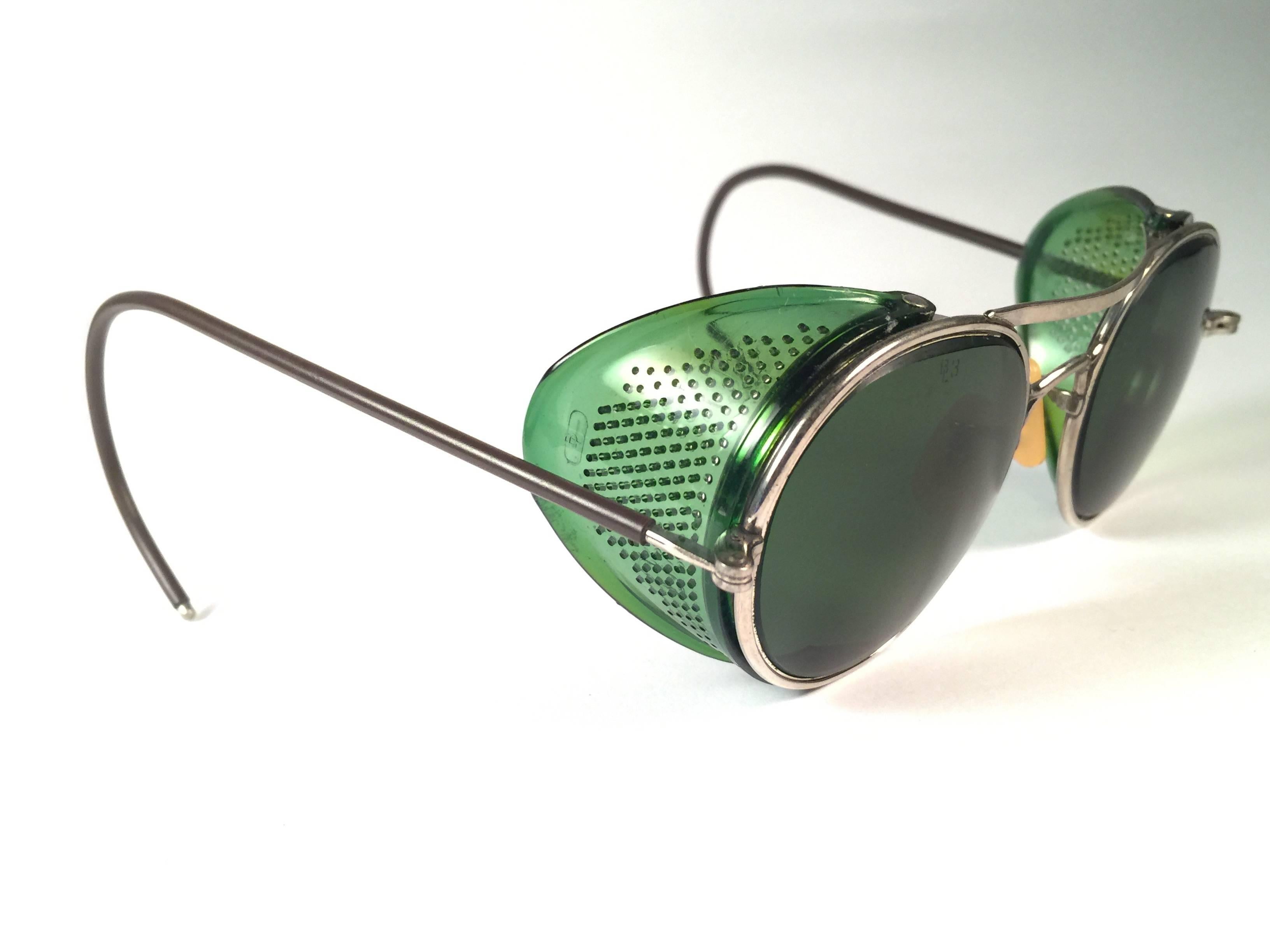 Superb Item! 1950's Bausch & Lomb Safety Goggles.  
Folding green and silver metal side cups and special wrapped temples.  Mint true green round lenses with light wear on them. 
Please note that this item is nearly 70 years old and has some