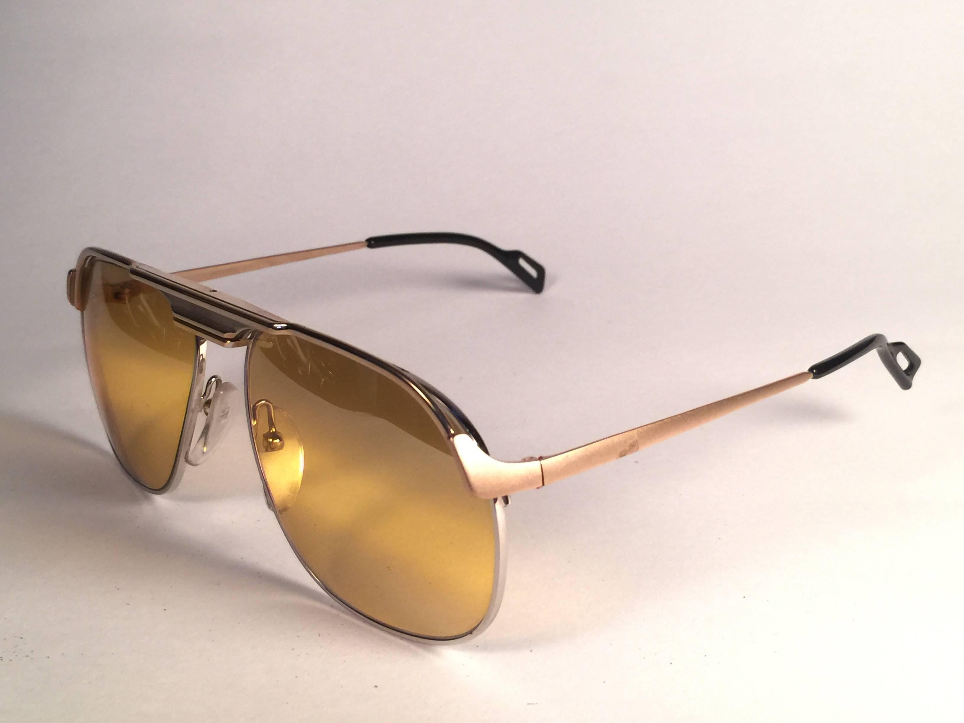 New Vintage Essilor with yellow and white gold accents sunglasses. 

Sturdy and cool frame sporting a pair of gold  double mirror lenses.  

Never worn or displayed. 
This item may show minor sign of wear due to nearly 40 years of storage.  Designed