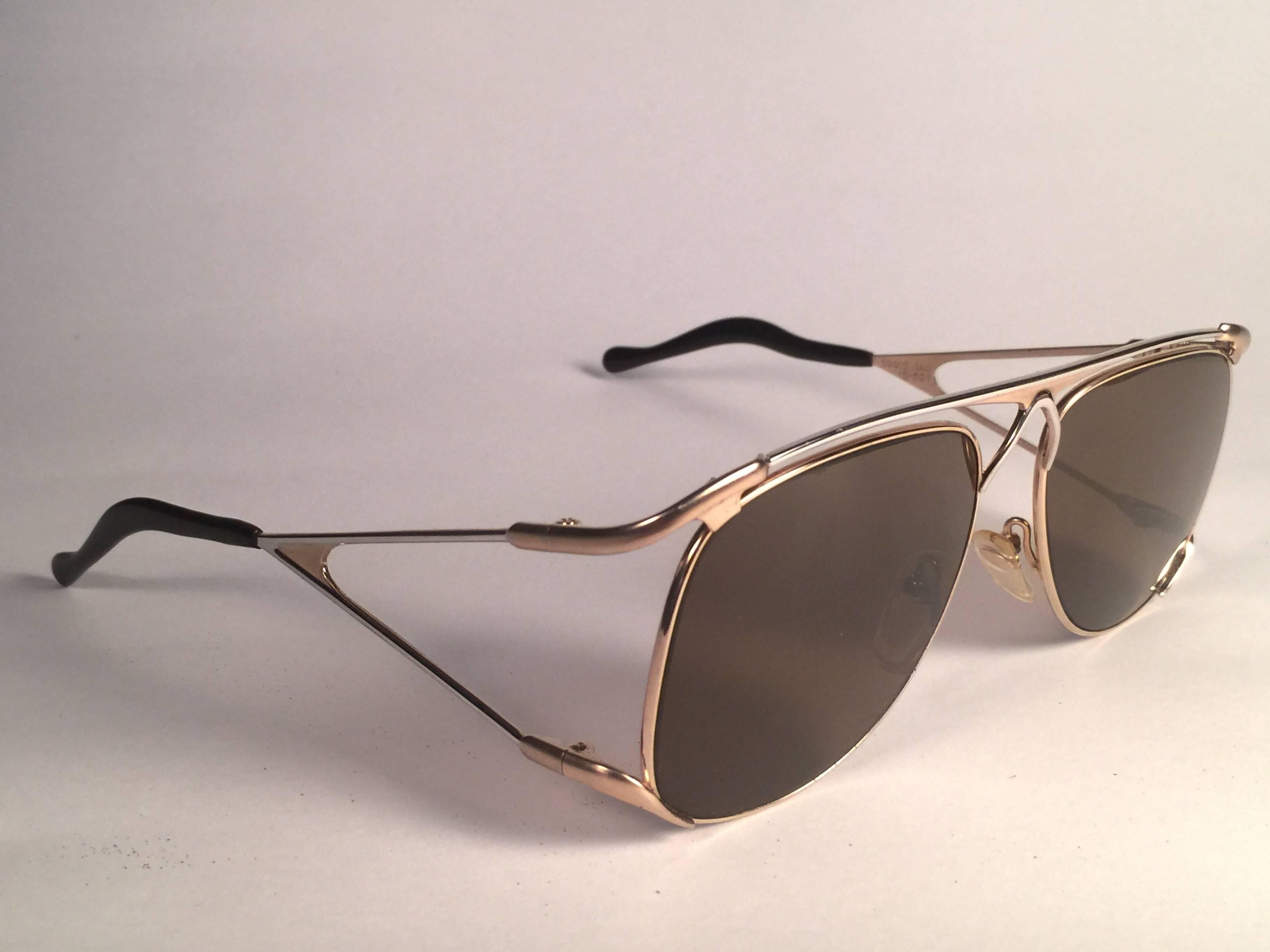 New Vintage Colani Design white and yellow gold accents sunglasses. 
Cut out frame sporting a pair of solid brown lenses.  
Never worn or displayed.
This item may show minor sign of wear due to nearly 40 years of storage.  Designed and produced in