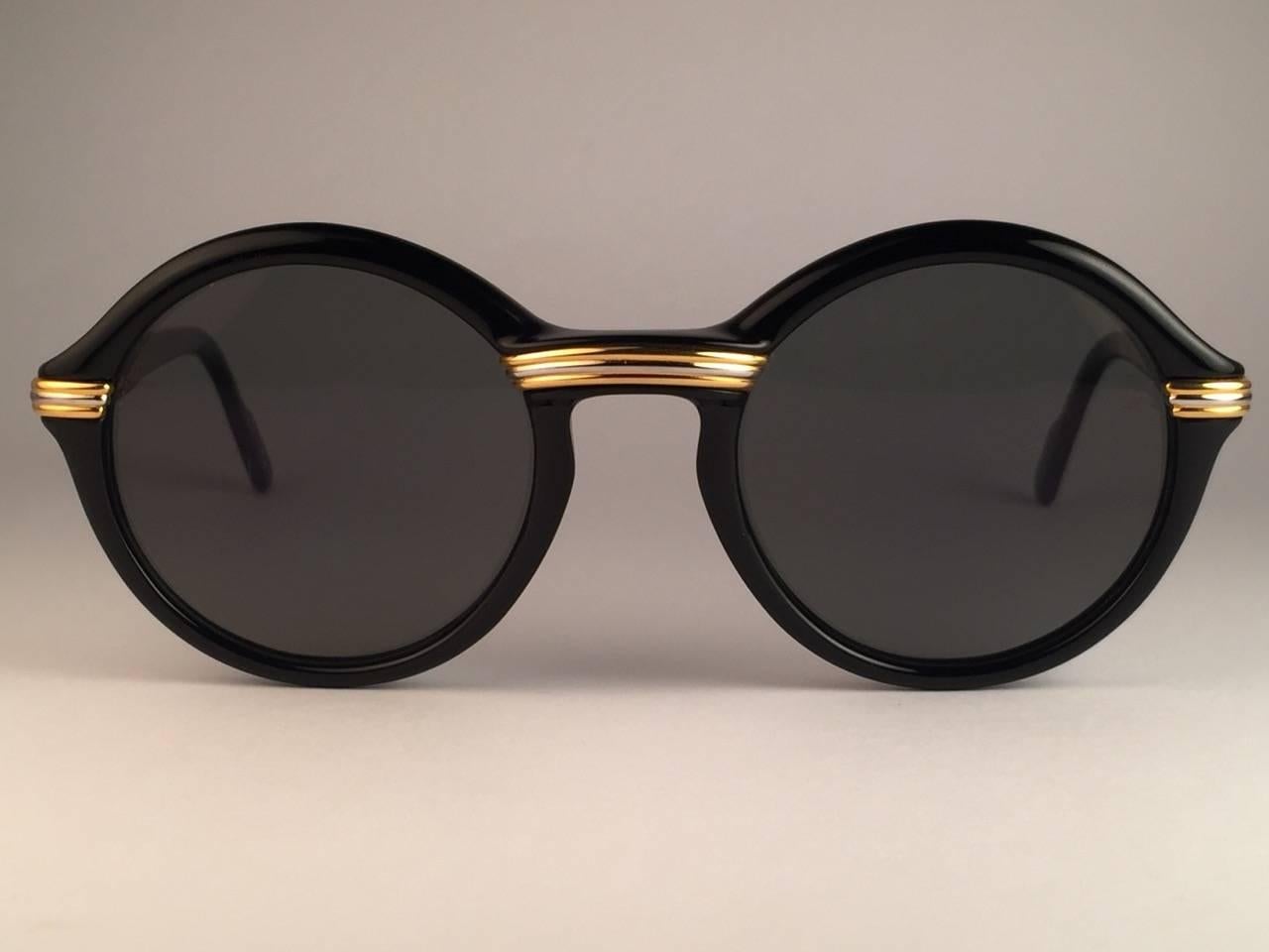 New 1991 Original Cartier Cabriolet Art Deco Black & Gold Sunglasses with slight gold mirror ( uv protection ) lenses Frame has the famous real gold and white gold accents in the middle and on the sides.  All hallmarks. Cartier gold signs on the