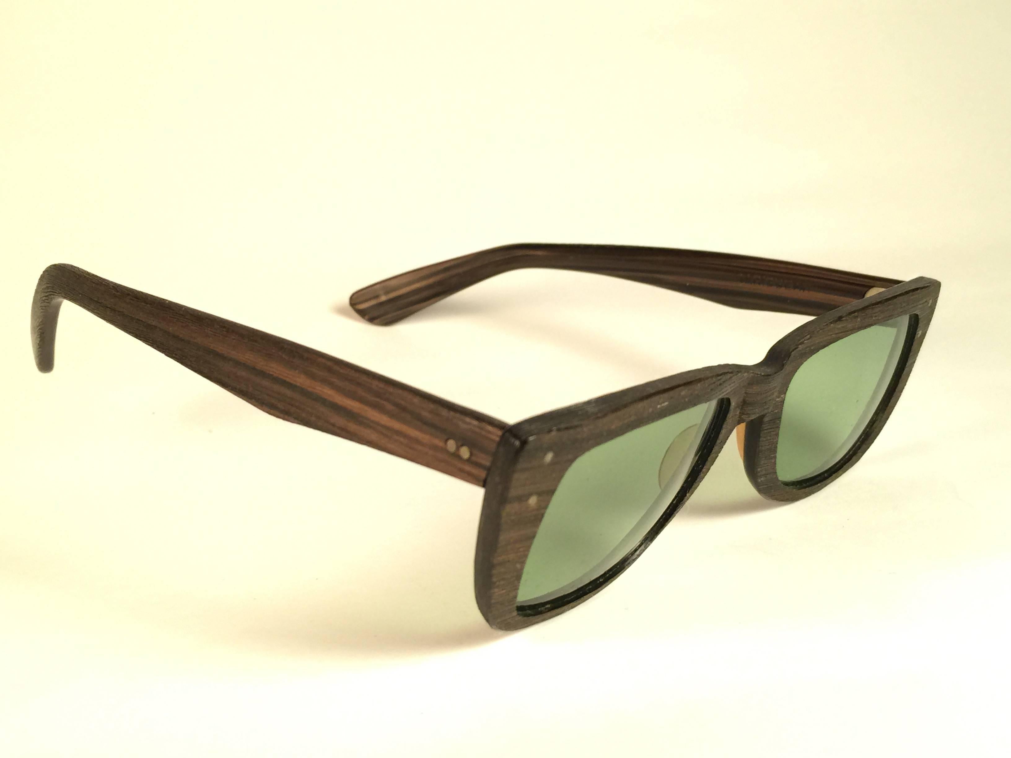 Super Rare 1960's Caribbean in dark wood with thinner and elongated temples .  
Bausch and Lomb USA Made. RB3 Green lenses. Straight out of the 1960's. All hallmarks. Minor sign of wear due to 60 years of storage. A Piece of sunglasses history.