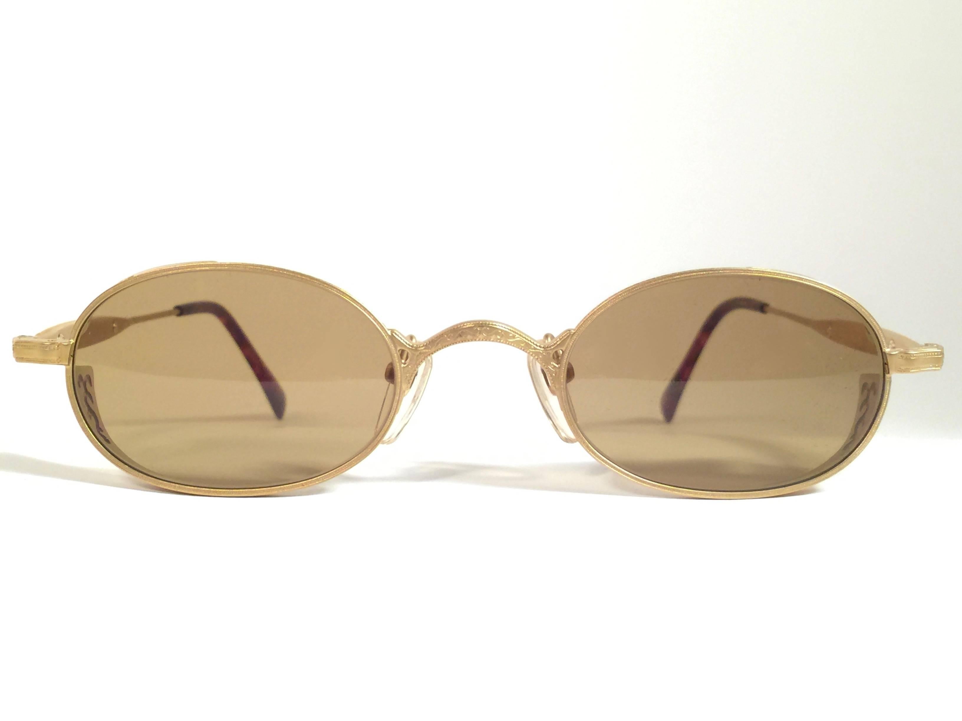 Cult brand Matsuda signed this ultra chic pair of matte gold oval with sumptuous engraved details sunglasses.   Spotless medium brown lenses.  Superior quality and design.   New, never worn or displayed. Made in japan.

MEASUREMENTS 

FRONT : 13.5