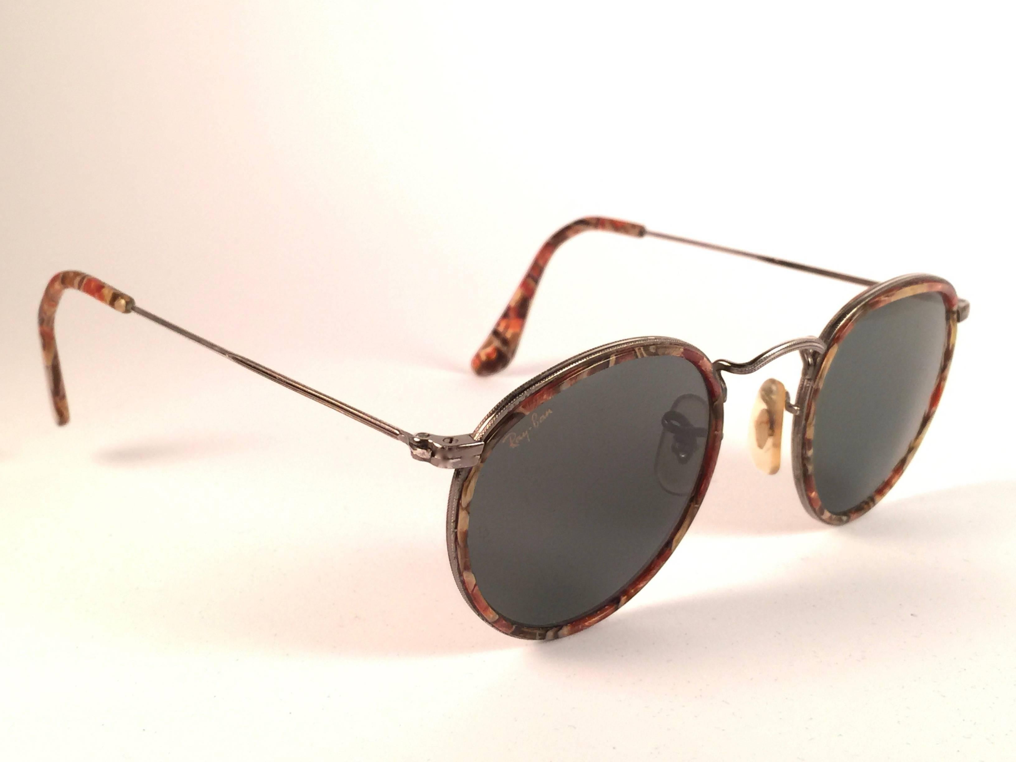 Mint Vintage Ray Ban round copper with mosaic inserts sunglasses. Lenses are G15 Grey, B&L etched in the lenses. 
Comes with its original Ray Ban B&L case.  
This piece may show minor sign of wear due to storage on the frame.  light scratches on