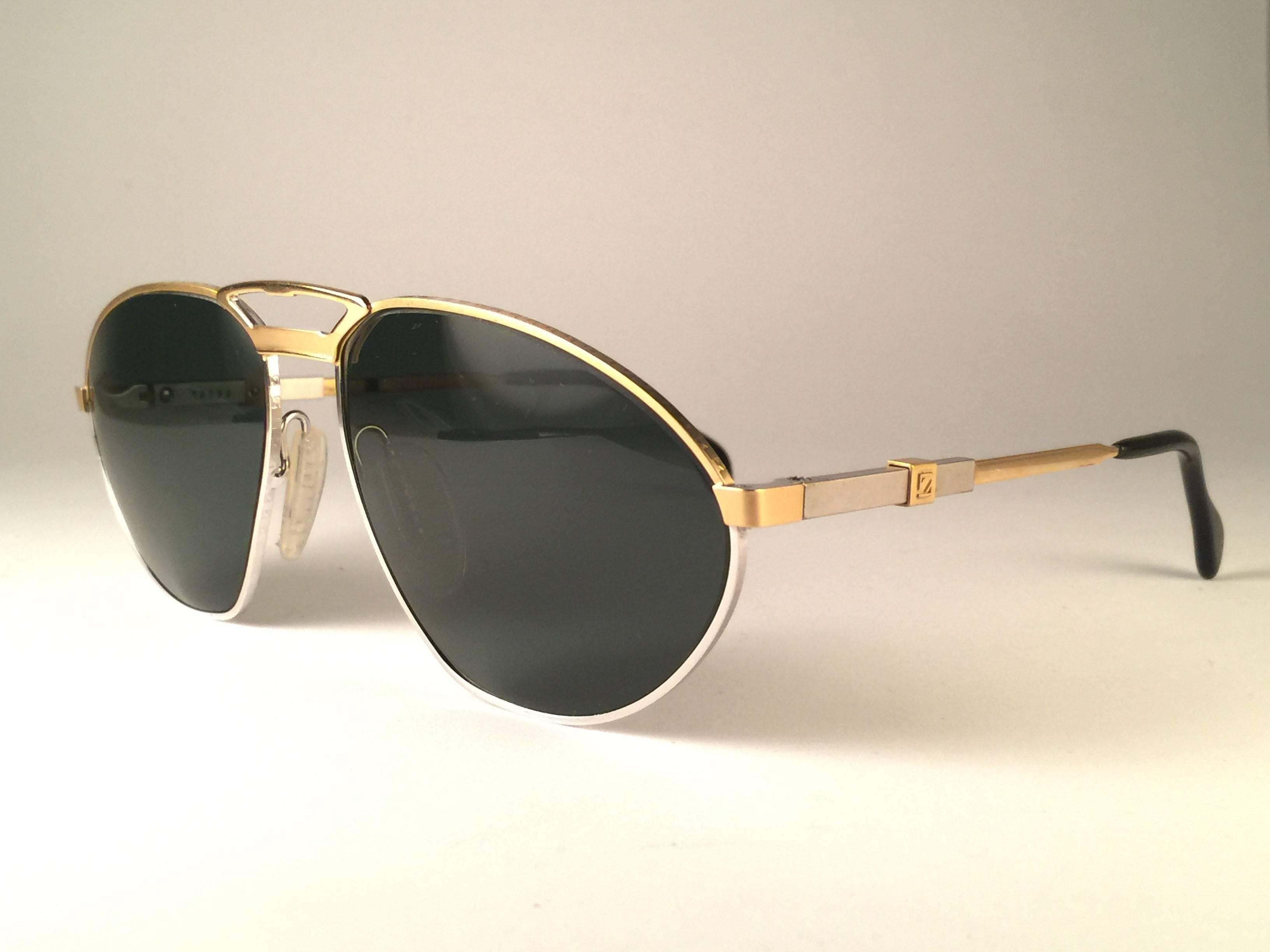 New Vintage Zeiss Competition Sunglasses in Silver and gold frame holding a pair of grey lenses. This item may show light sign of wear due to storage.

 Made in West Germany.