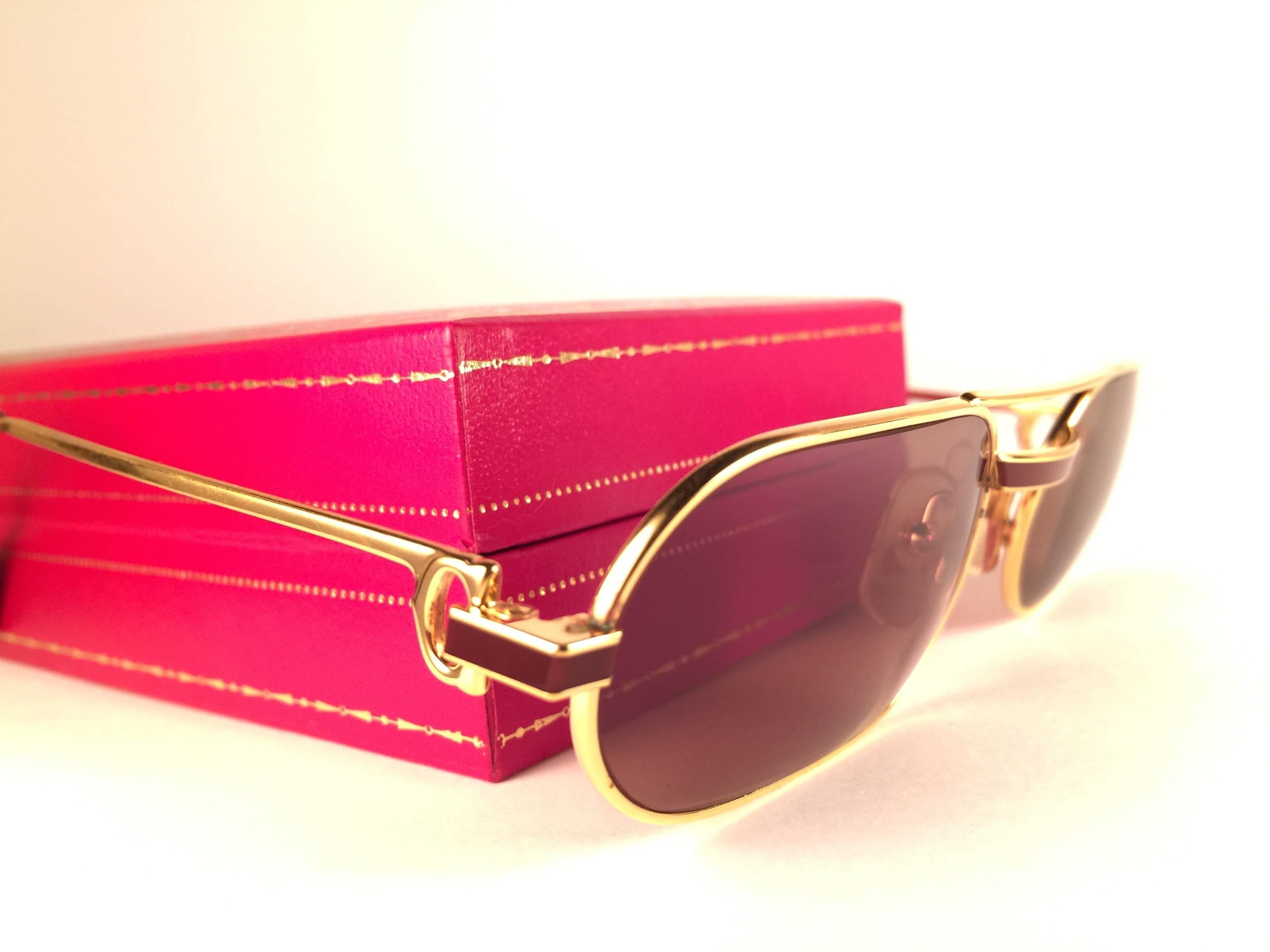 Original 1983 Cartier Louis Cartier Laque De Chine sunglasses with new honey brown lenses. All hallmarks. Red enamel with Cartier gold signs on the burgundy ear paddles. Both arms sport the C from Cartier on the temple. These are like a pair of