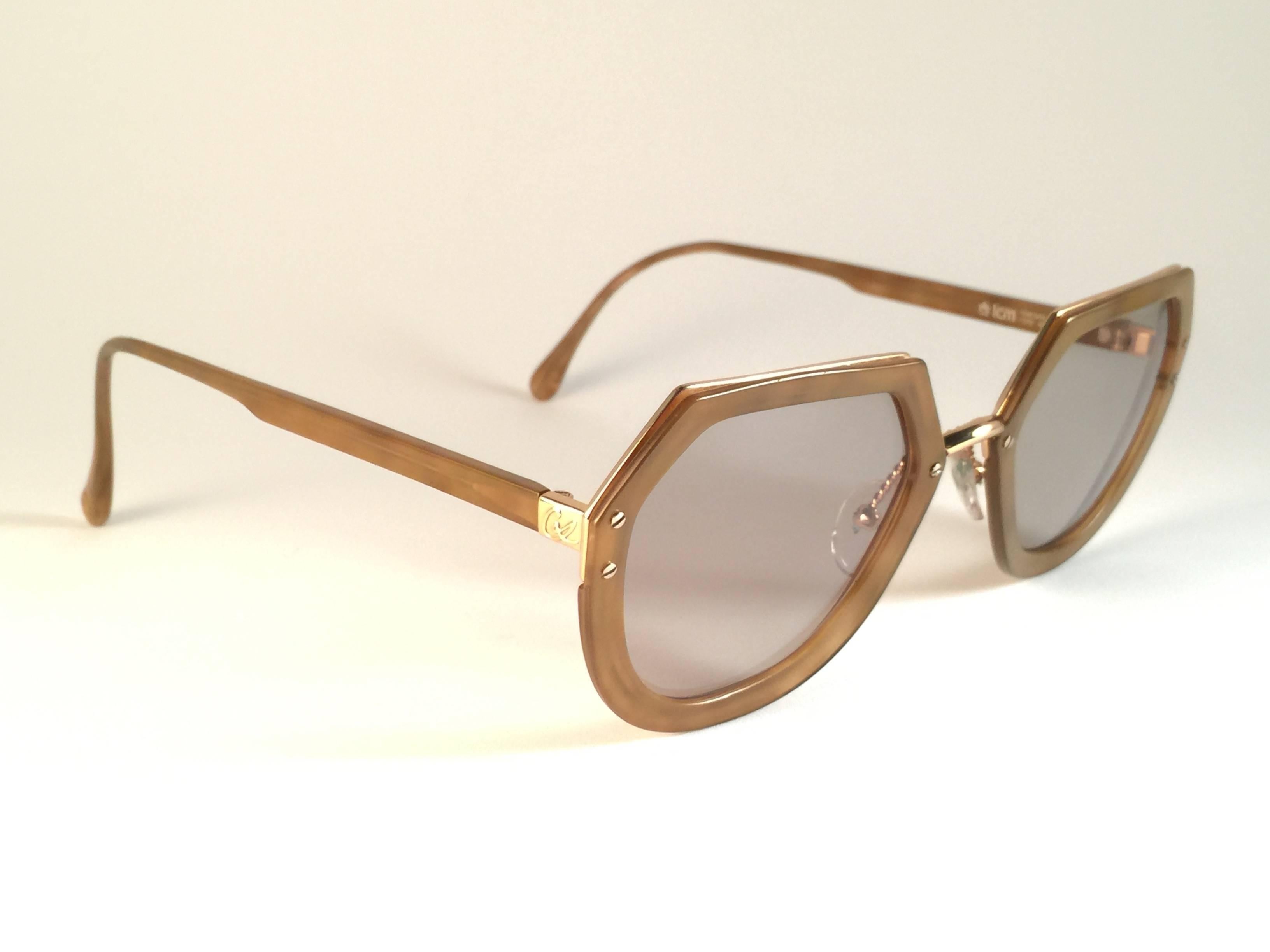 Superb & rare pair of New vintage Christian Lacroix sunglasses.   

Ocre with gold accents frame holding a pair of spotless amber lenses.   

New, never worn or displayed. This pair may have minor sign of wear due to storage.

Made in France.