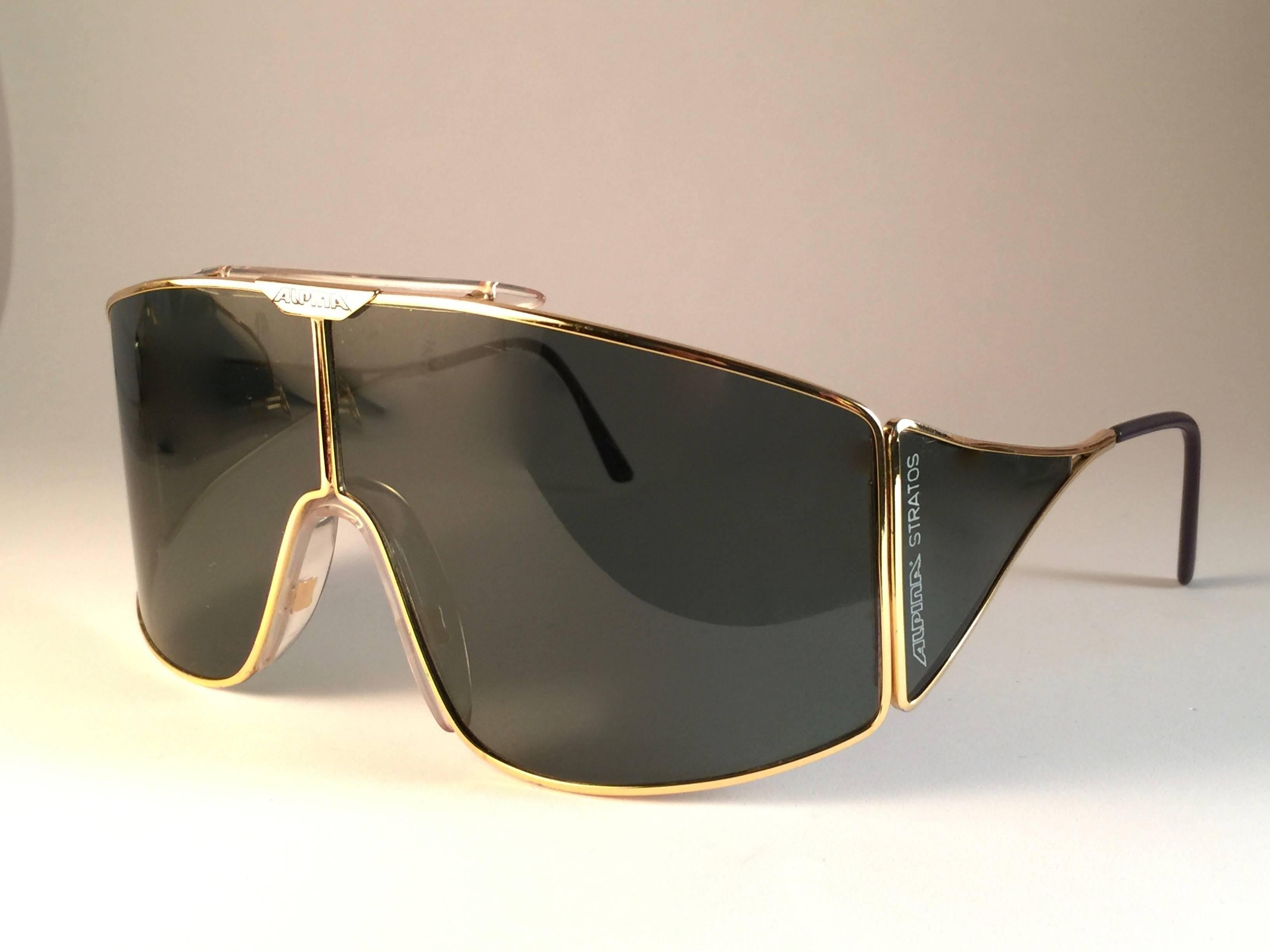 New Vintage Alpina Stratos Sunglasses. Gold frame with green mono lens and side cups. 

Comes with its original Alpina case. This pair may show minor sign of wear due to storage.

Made in West Germany.