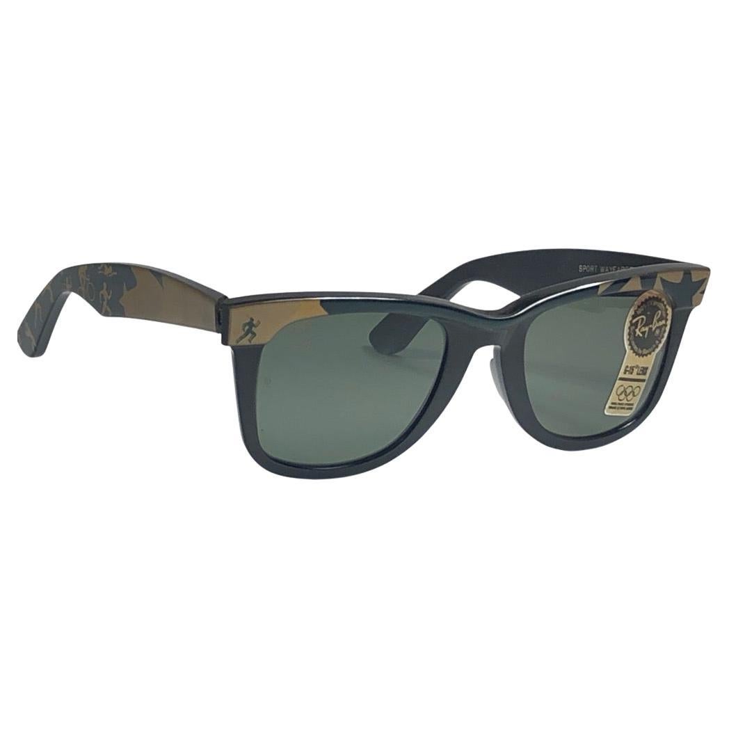 Nueva Wayfarer clásica Juegos Olímpicos de Atlanta 1996. B&L grabado en ambas lentes grises G15. 
Ten en cuenta que este artículo tiene casi 40 años y podría mostrar cierto desgaste por almacenamiento.  
Nuevo, nunca usado ni expuesto.

Fabricado en