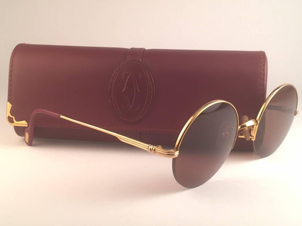 
New 1990 Cartier Mayfair half frame sunglasses with brown (uv protection) lenses. 
Frame is with the front and sides in gold. All hallmarks. Cartier gold signs on the ear paddles. 
These are like a pair of jewels on your nose.
Beautiful design and