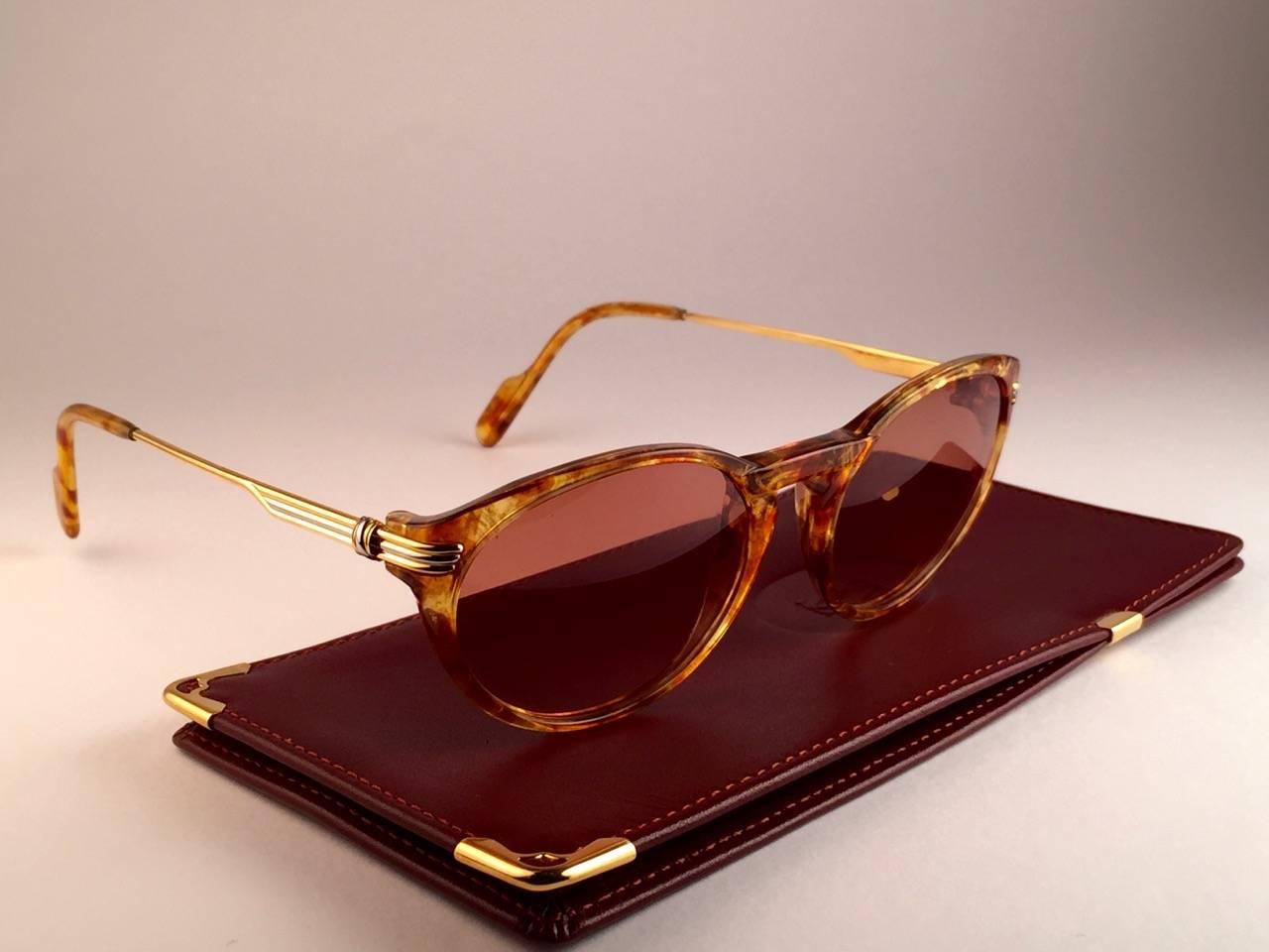 
New Cartier Aurore Classic sunglasses with brown (uv protection) lenses. Small size 50mm/18 frame has the famous real gold and white gold accents on the temples. 100% original. All hallmarks. Cartier gold signs on the earpaddles. These are like a