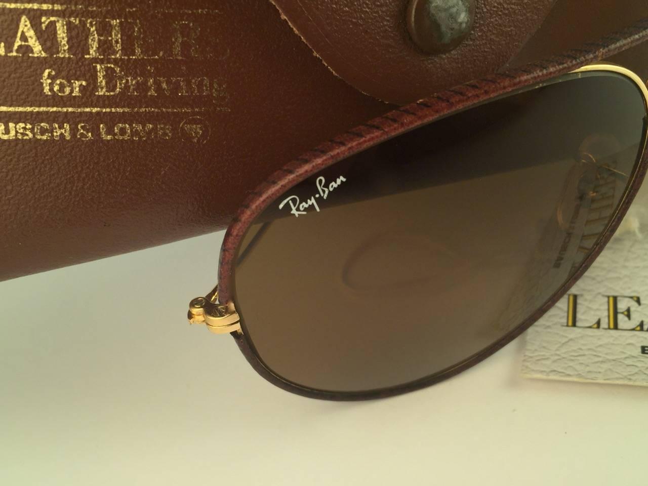 New Vintage Ray Ban Leathers Aviator 62mm in tobacco brown leather with gold metal combination frame sporting B15 brown lenses with white Ray Ban logo. 

B&L etched in the lenses, so mid 1970's. 

Comes with its original Ray Ban B&L case with minor