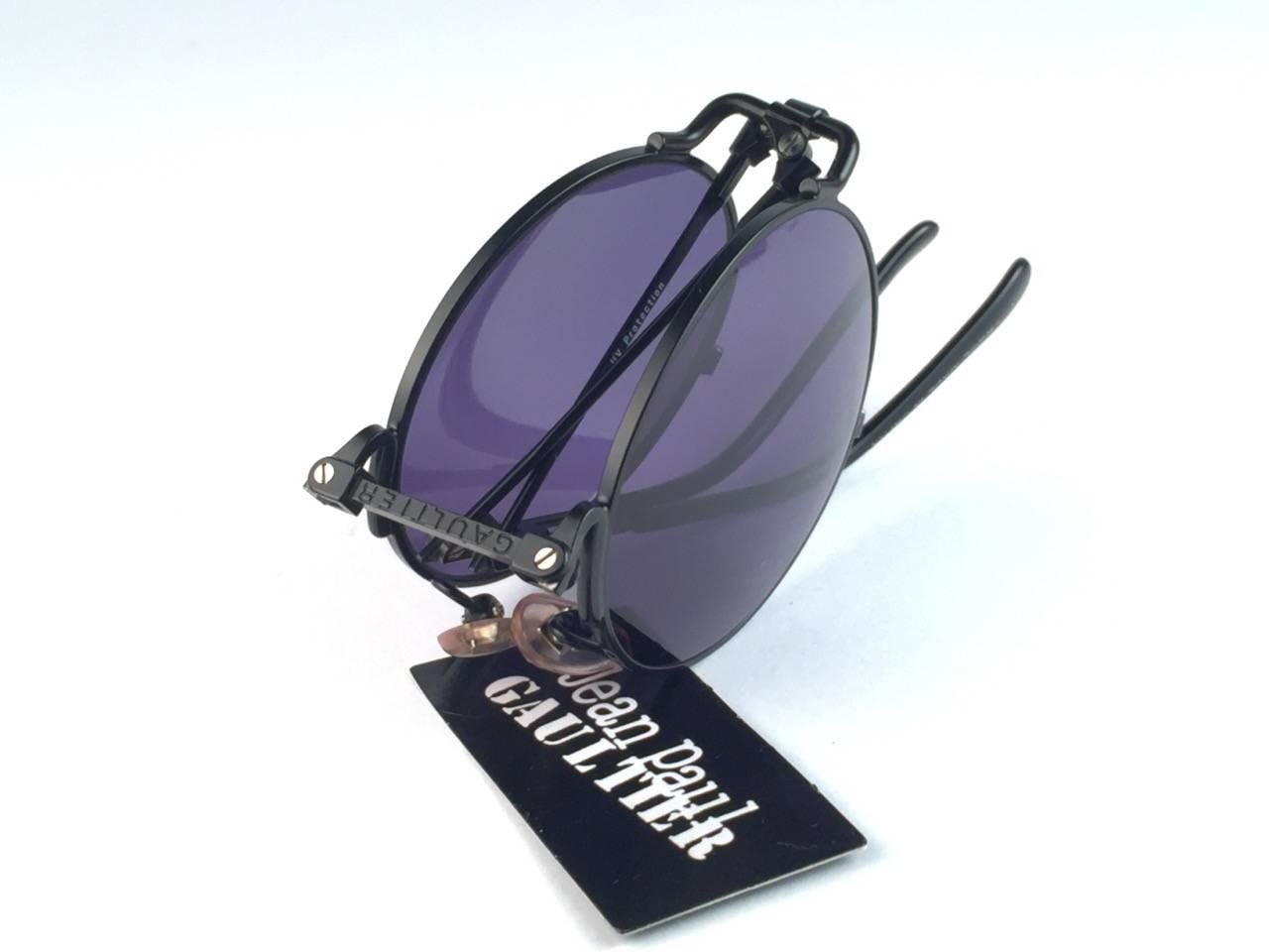 New Jean Paul Gaultier 56 9171 Round Black Foldable Frame. 
Dark Blue lenses that complete a ready to wear JPG look.

Amazing design with strong yet intricate details.
Design and produced in the 1900's.
New, never worn or displayed.
A true fashion